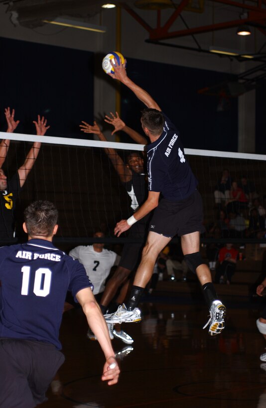 FORT LEWIS, Wash. - Staff Sgt. Jason McDonald tips the ball over Army blockers to throw off the defense. Sergeant McDonald was selected as one of the top 12 players at the 2004 All Armed Forces Volleyball Tournament held here June 22.  The 12 best players selected from all four services will represent the U.S. military at the International Military Sports Council World Championship and face their counterparts from other nations. Sergeant McDonald is assigned to Dyess Air Force Base, Texas.  (U.S. Air Force photo by Senior Airman Meghan Geis)