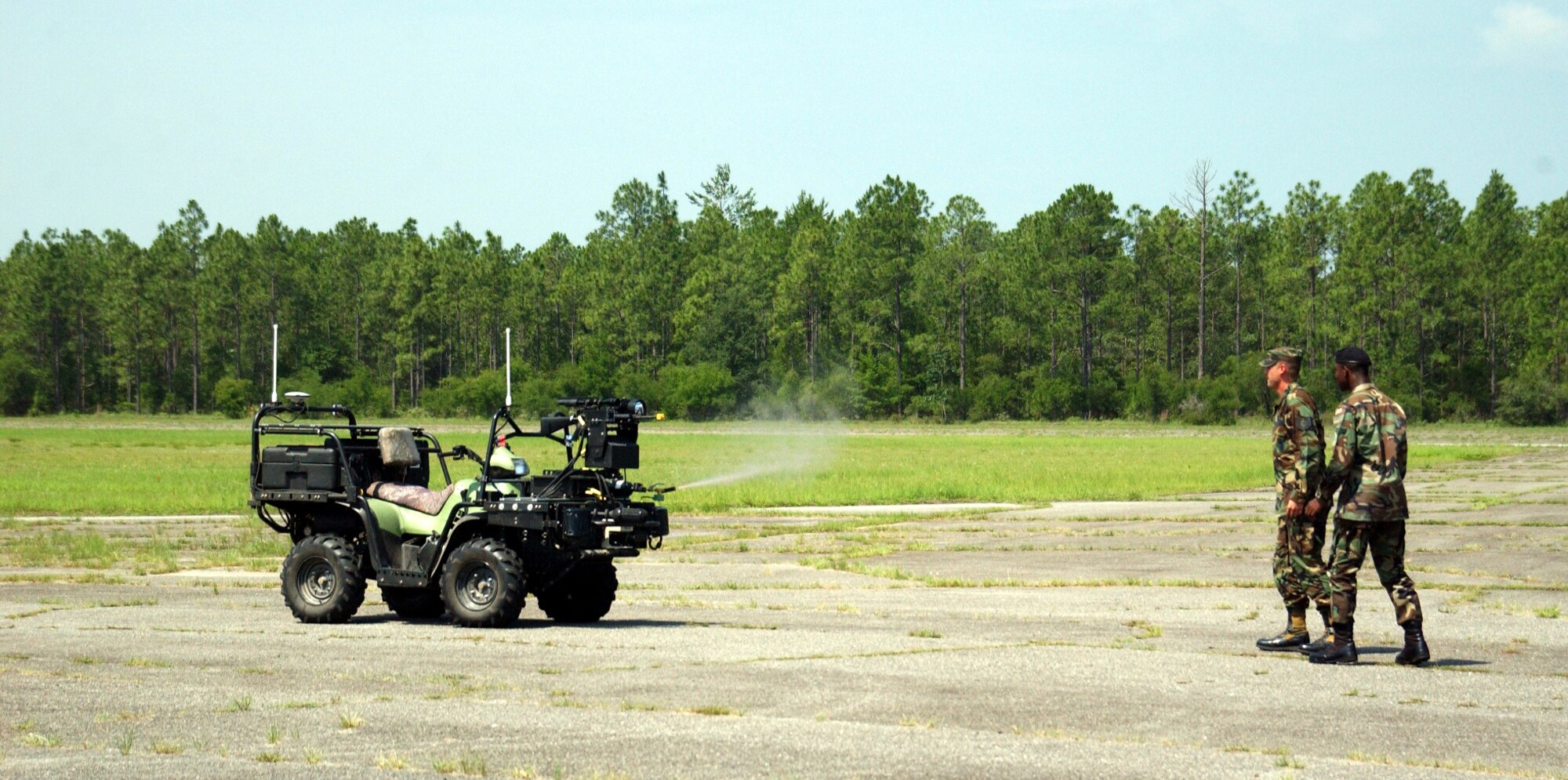 EGLIN AIR FORCE BASE, Fla. -- Troops stand back as the Scout robotic vehicle fires pepper spray during a demonstration June 22.  The robot is also armed with an M-16A2 rifle which is controlled from a remote location.  (U.S. Air Force photo by Gary Emery)