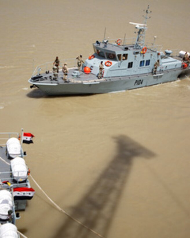Iraqi Coastal Defense Force Patrol Craft 104 makes its way to a demonstration as part of the opening ceremony of the Defense Force base in Umm Qasr, Iraq, on June 12, 2004. The Force was created in January 2004 and trained under British-led coalition forces to provide search and rescue, anti-smuggling, policing and other defense capabilities along the coastline of Iraq. 