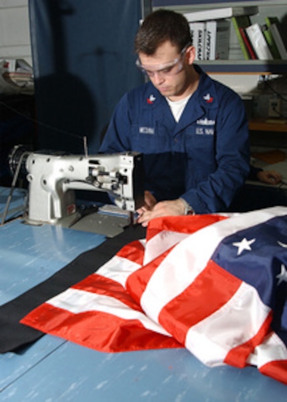 Petty Officer 2nd Class Eric Medina carefully mends an American flag in the Canvas Shop aboard the USS George Washington (CVN 73) on June 21, 2004, underway in the Persian Gulf. Medina, from Houston, Texas, is a Navy Boatswain's Mate aboard the nuclear powered aircraft carrier, which is deployed in support of Operation Iraqi Freedom. 
