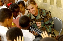 TIMERHRI, Guyana -- Students from a primary school here watch as Staff Sgt. Tonia Morgan plays a video of them at a construction site June 23 during exercise New Horizons 2004-Guyana.  About 200 U.S. Airmen, Soldiers and Sailors are participating in the four-month joint training exercise co-sponsored by U.S. Southern Command and the Guyana defense force.  A combined team of engineers and medics is working on construction projects and medical-training activities.  Sergeant Morgan is assigned to the 1st Combat Camera Squadron based at Charleston Air Force Base, S.C.  (U.S. Air Force photo by Staff Sgt. Sarayuth Pinthong)