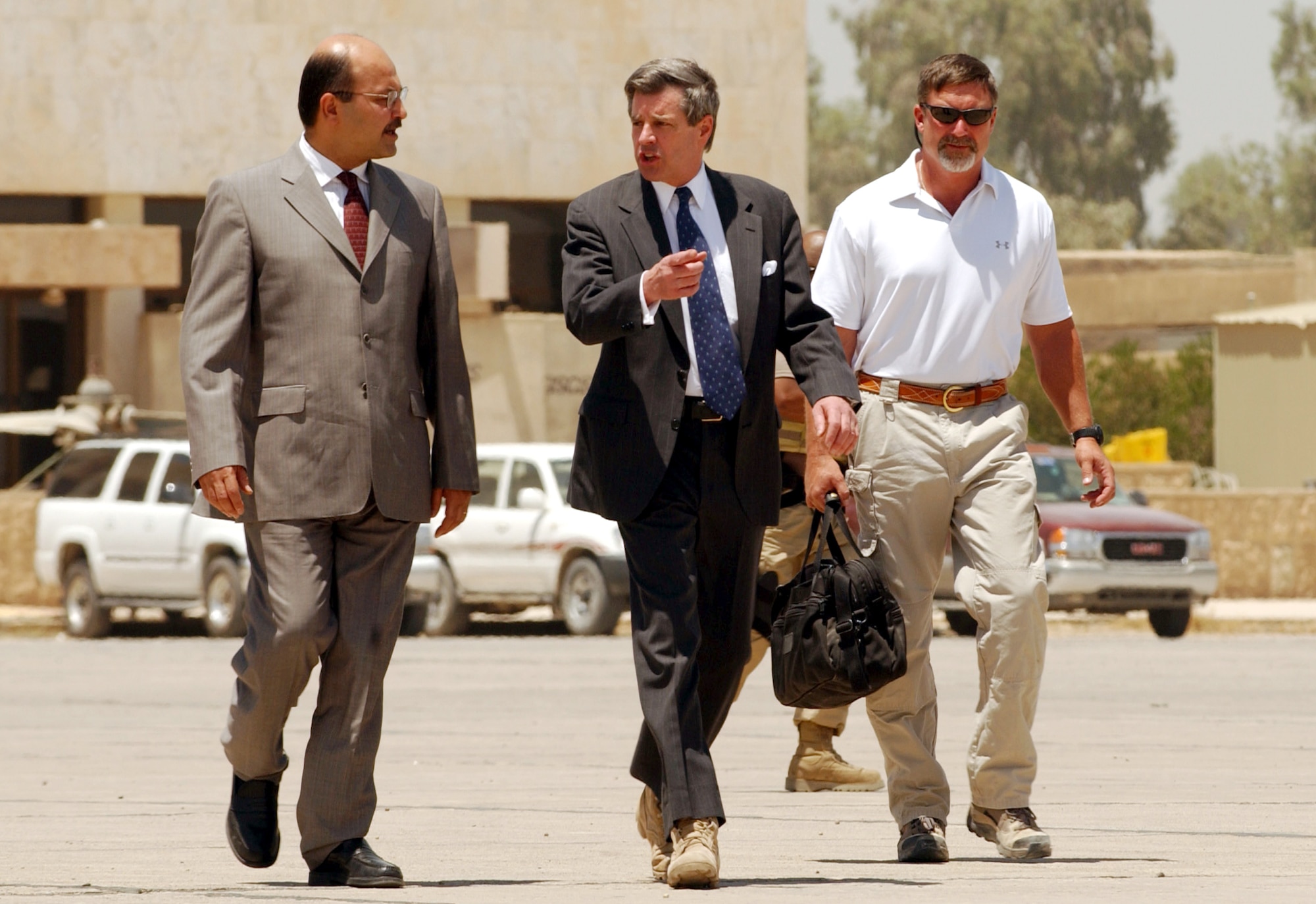 BAGHDAD, Iraq -- L. Paul Bremer III (center) leaves the "Green Zone" after signing the Iraqi sovereignty document giving authority to the interim Iraqi government here June 28.  Mr. Bremer left on an Army Chinook helicopter, arrived at Baghdad international airport and made his final departure from Iraq in an Air Force C-130 Hercules.  (U.S. Air Force photo by Staff Sgt. D. Myles Cullen)