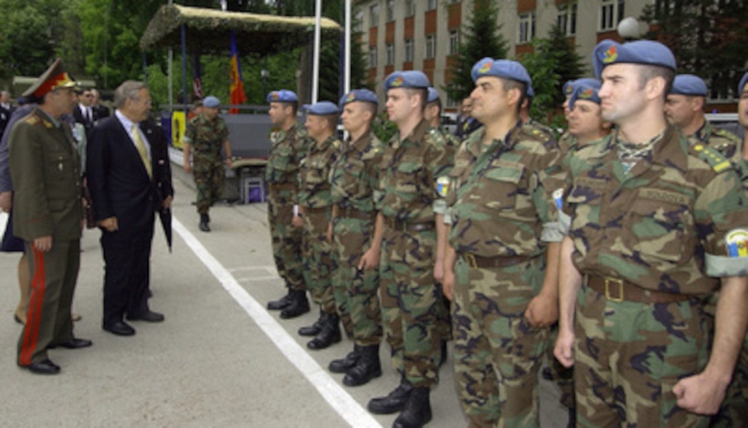 Secretary of Defense Donald H. Rumsfeld (right) and Moldovan Minister of Defense Brig. Gen. Victor Gaiciuc talk to Moldovan soldiers of the 2nd Brigade in Chisinau, Moldova, on June 26, 2004. Rumsfeld is visiting Moldova prior to attending the NATO Summit in Istanbul, Turkey. 
