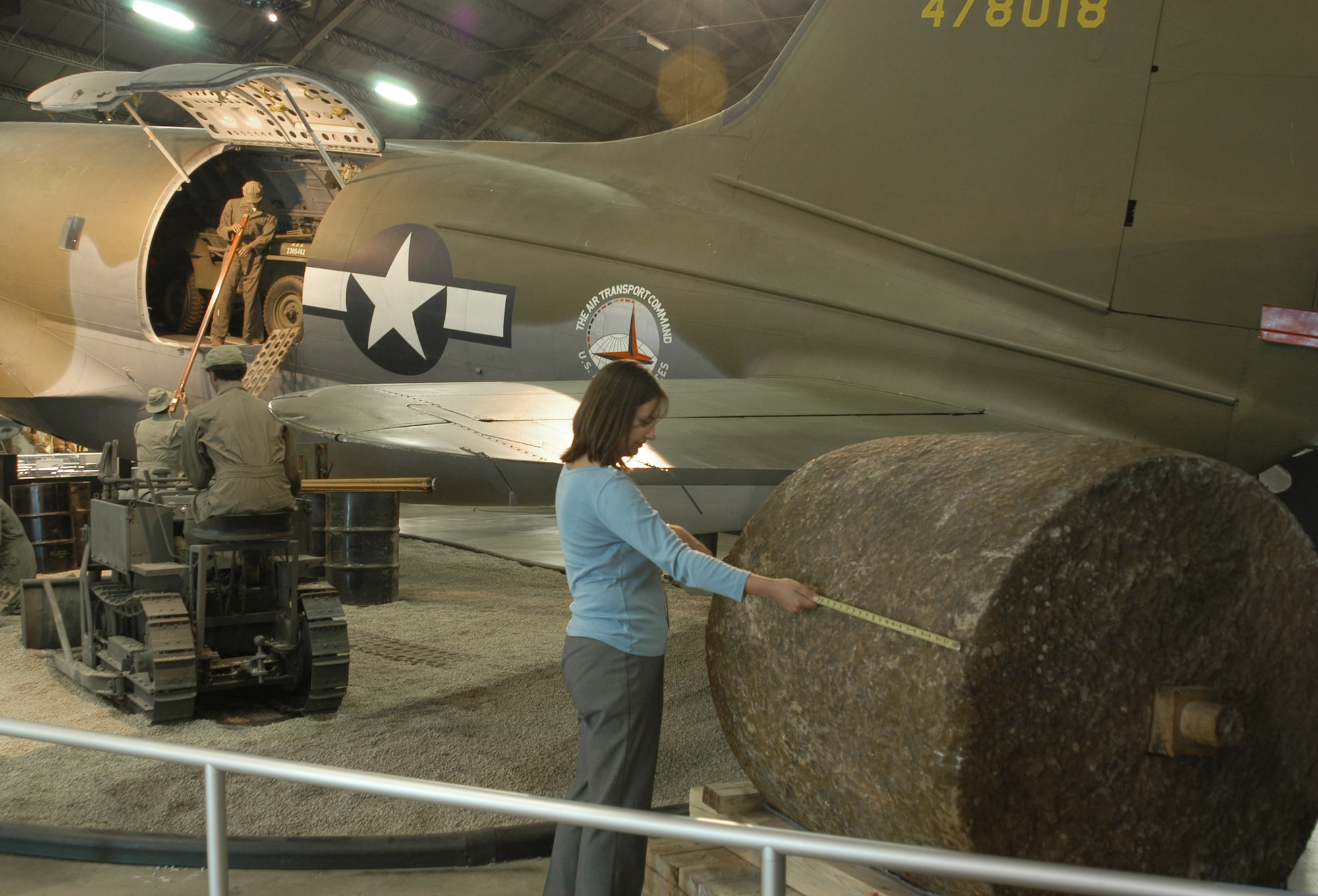 DAYTON, Ohio -- U.S. Air Force Museum technician Roberta Carothers measures a recently donated stone roller before its display in the museum's air power gallery.  The stone roller was used to compress gravel for runways as long as 8,500 feet in Kunming, China.  The runways were used by the Flying Tigers and other aircraft during World War II.  (U.S Air Force photo by 1st Lt. Gailyn F. Whitman)