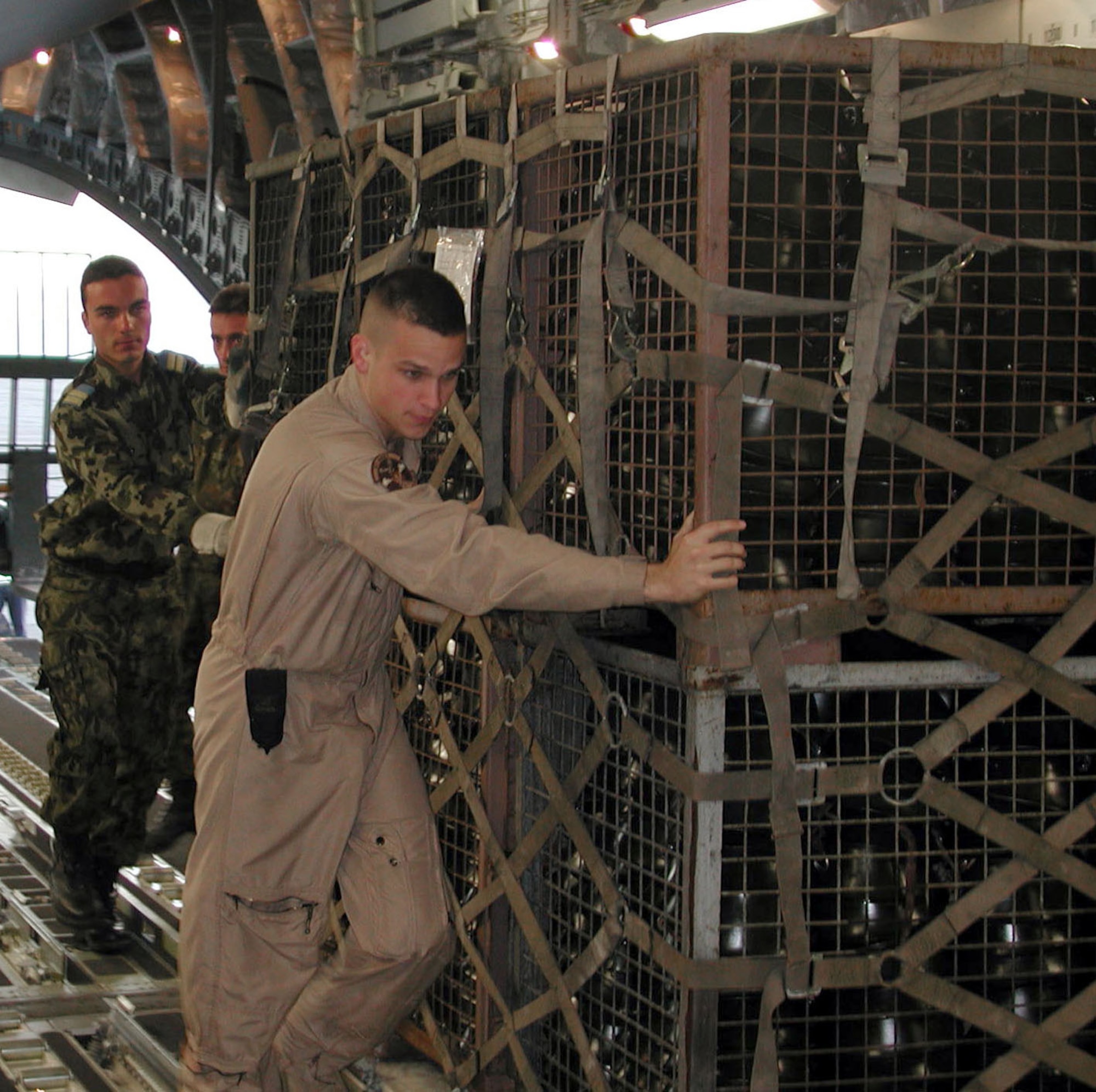 MIHAIL KOGALNICEANU AIR BASE, Romania -- Senior Airman Derrick Dirmeyer helps Romanian airmen load 17 pallets of military helmets onto a C-17 Globemaster III here June 24.  The helmets were donated by the Romanian government to the Afghan army and flown to Afghanistan by a U.S. Air Force Reserve aircrew from the 97th Airlift Squadron at McChord Air Force Base, Wash.  Airman Dirmeyer is a crew chief assigned to the 62nd Aircraft Maintenance Squadron at McChord AFB.  (U.S. Air Force photo by Capt. Chris Watt)