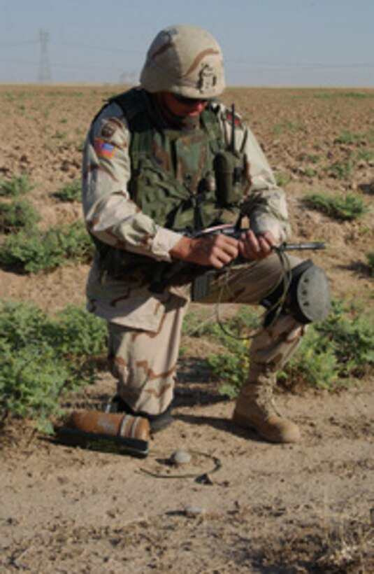 Army Sgt. 1st Class Michael Morris arms the C-4 explosive attached to a 115mm anti-tank round found while searching for unexploded ordnance during a patrol in the town of Bayji, Iraq, on June 19, 2004. Morris, a member of Alpha Company 9th Engineers will detonate the explosive to destroy the round. 