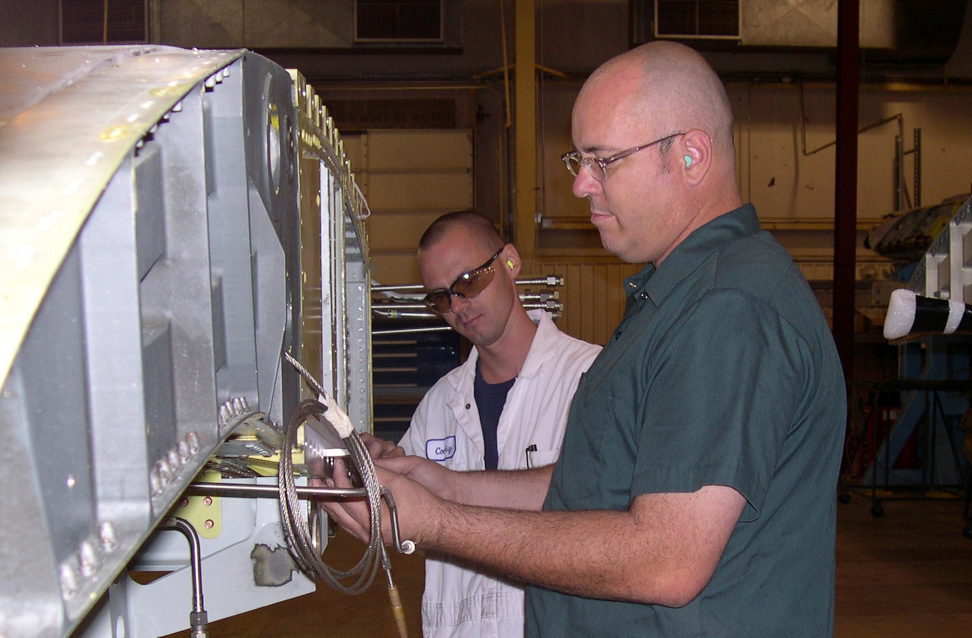 DAVIS-MONTHAN AIR FORCE BASE, Ariz. -- Mark Perrodin (foreground) and Chris Duggie mount a template to an A-10 Thunderbolt II center wing assembly as part of A-10 service-life extension work.  Both men are aircraft structural technicians with the Aerospace Maintenance and Regeneration Center here.  (U.S. Air Force photo by Tech. Sgt. Brian Davidson)