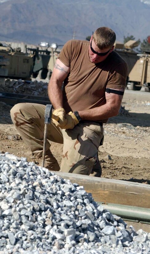 BAGRAM AIR BASE, Afghanistan -- Staff Sgt. Scott Haas drives a stake during construction of a new A-10 Thunderbolt II maintenance building's concrete driveway.  Sergeant Haas is a civil engineer with the 455th Expeditionary Operations Group, and he is deployed from Ellsworth Air Force Base, S.D.  (U.S. Air Force photo by Master Sgt. Jeff Szczechowski)
