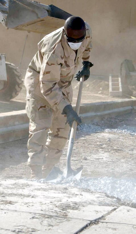 BAGRAM AIR BASE, Afghanistan -- Airman 1st Class Collins Osei levels gravel before concrete is poured for a new A-10 Thunderbolt II maintenance building's driveway.  Airman Osei is a civil engineer with the 455th Expeditionary Operations Group, and he is deployed from Ellsworth Air Force Base, S.D.  (U.S. Air Force photo by Master Sgt. Jeff Szczechowski)