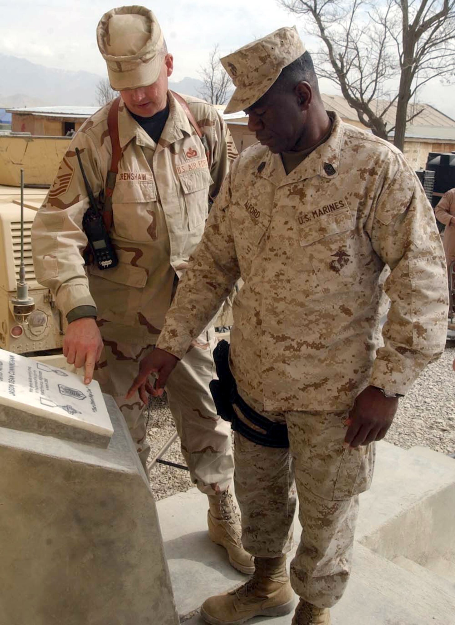 BAGRAM AIR BASE, Afghanistan -- Master Sgt. Taylor Crenshaw and Marine Sgt. Maj. Jerome Alford take a moment to reflect on the life of Senior Airman Jason. D. Cunningham at a monument dedicated to him.  Airman Cunningham was a pararescueman killed in action during Operation Enduring Freedom.  Sergeant Crenshaw is the first sergeant of the 455th Expeditionary Operations Group.  (U.S. Air Force photo by Master Sgt. Jeff Szczechowski)