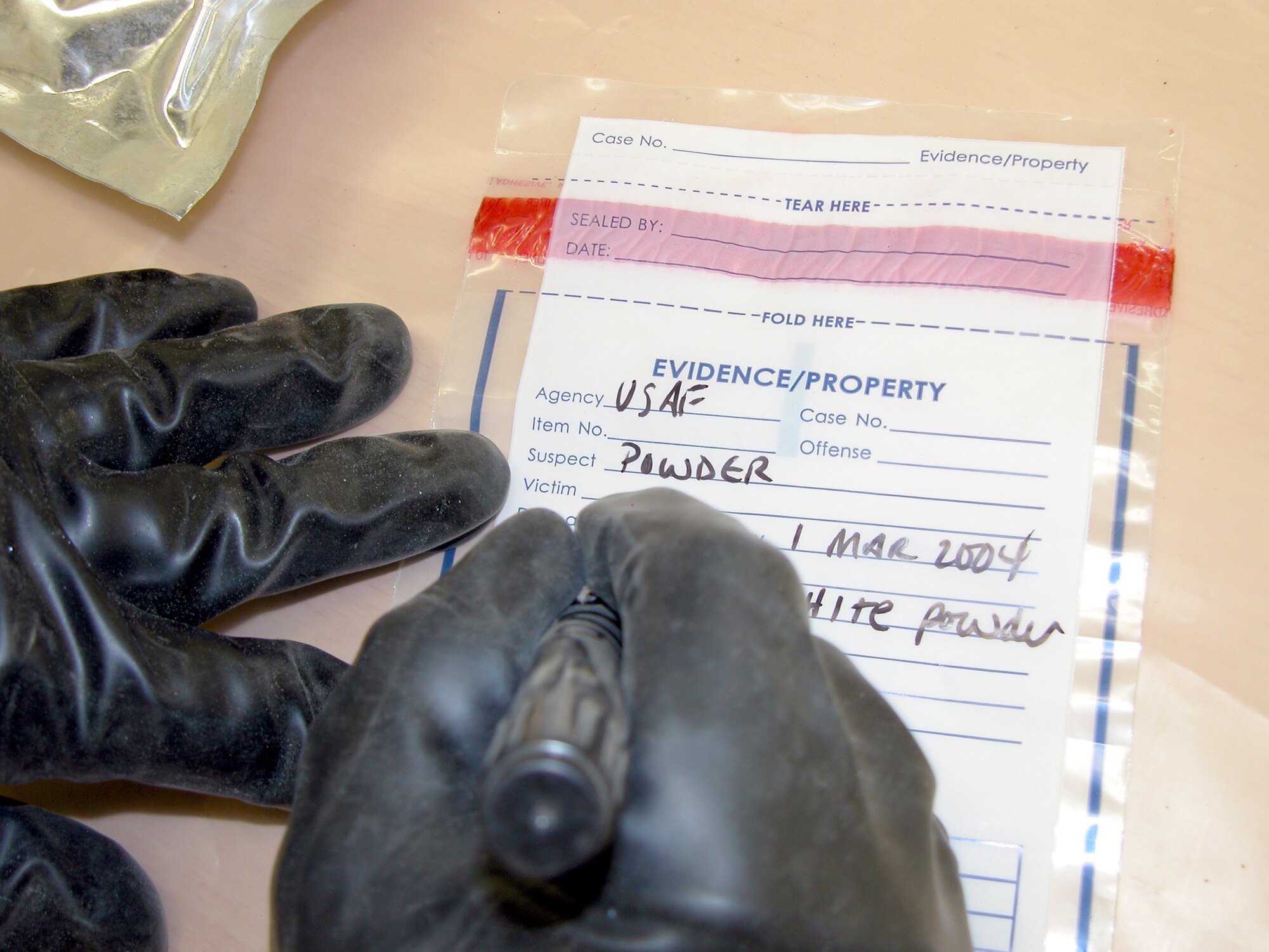 TALLIL AIR BASE, Iraq -- Staff Sgt. William Hall fills out an evidence bag during a biological identification training exercise here March 1.  Sergeant Hall is a readiness journeyman deployed from Aviano Air Base, Italy, and one of seven Airmen here trained to detect nuclear, biological and chemical agents.  (U.S. Air Force photo by Tech. Sgt. Bob Oldham)
