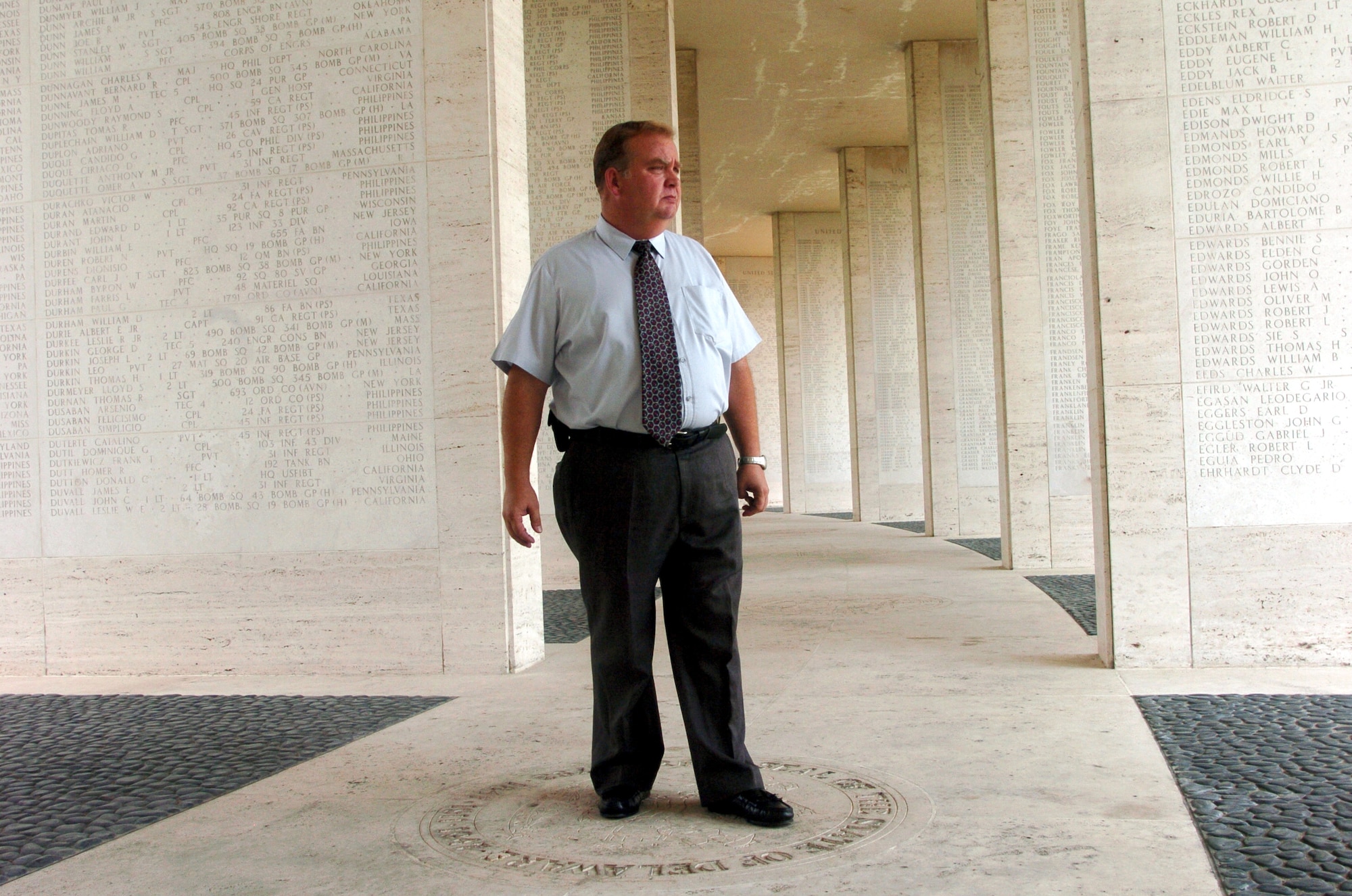 MANILA, Philippines -- Superintendent Dan Neese stands in a hall of the Wall of Missing at the Manila American Cemetery and Memorial here during his daily rounds.  The cemetery is the final resting place for 17,206 Americans from World War II.  A Wall of Missing is inscribed with 36,284 names.  (U.S. Air Force photo by Master Sgt. Val Gempis)