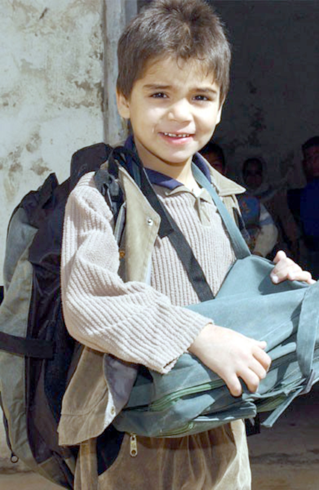 NASIRIYA, Iraq -- A school boy selects a backpack donated by 380th Air Expeditionary Wing Airmen.  More than 200 backpacks filled with school supplies and hygiene products were donated. (U.S. Air Force photo by Tech. Sgt. Bob Oldham)