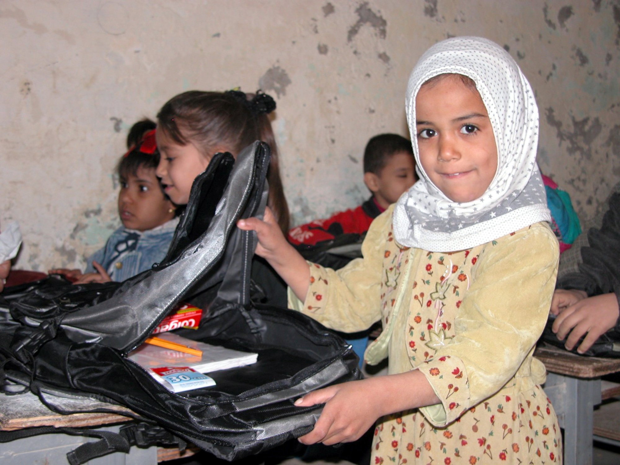 NASIRIYA, Iraq -- A school girl holds open a backpack recently delivered to her and more than 200 schoolmates by 380th Air Expeditionary Wing Airmen.  The backpacks were filled with school supplies and hygiene products.   (U.S. Air Force photo by Tech. Sgt. Bob Oldham)