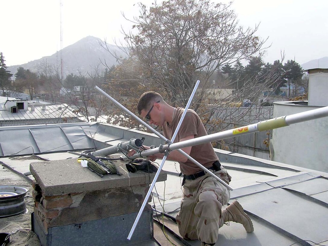 KABUL, Afghanistan -- Staff Sgt. Vincent Bess maintains an antenna on the roof of the Army's Criminal Investigative Division's personal security detail element here.  After installing a new repeater system and setting up the antenna, the improved radio communications helped provide better security for convoys rolling in and out of the Afghanistan capital.  Sergeant Bess is a ground-radio technician with the 455th Expeditionary Operations Group at Bagram Air Base, Afghanistan.  (U.S. Air Force photo by Staff Sgt. Andre Locust)