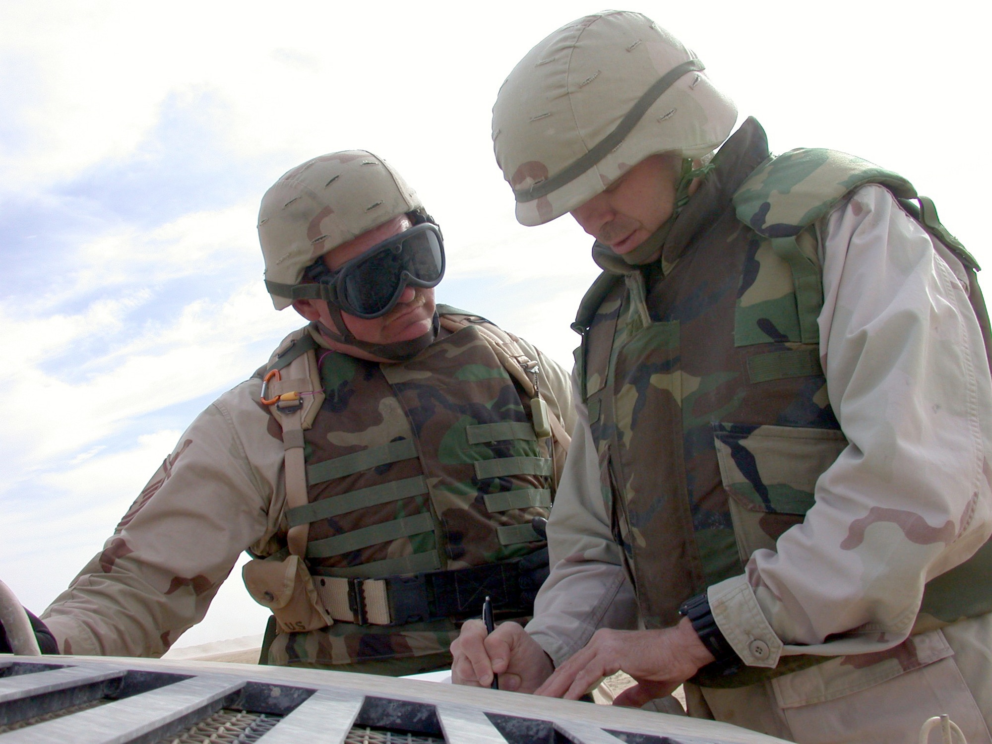 SOUTHWEST ASIA -- Master Sgt. David Voltz (left) speaks with John Fracassini, an instructor with Military Professional Resources Inc., after a convoy live-fire exercise.  The exercise was designed to teach transportation Airman how to fire on hostile forces, while continuing to travel through the "kill zone."  Sergeant Voltz was acting as the serial commander for the exercise.  He is deployed from Davis-Monthan Air Force Base, Ariz.  (U.S. Air Force photo by Senior Airman James C. DIllard)