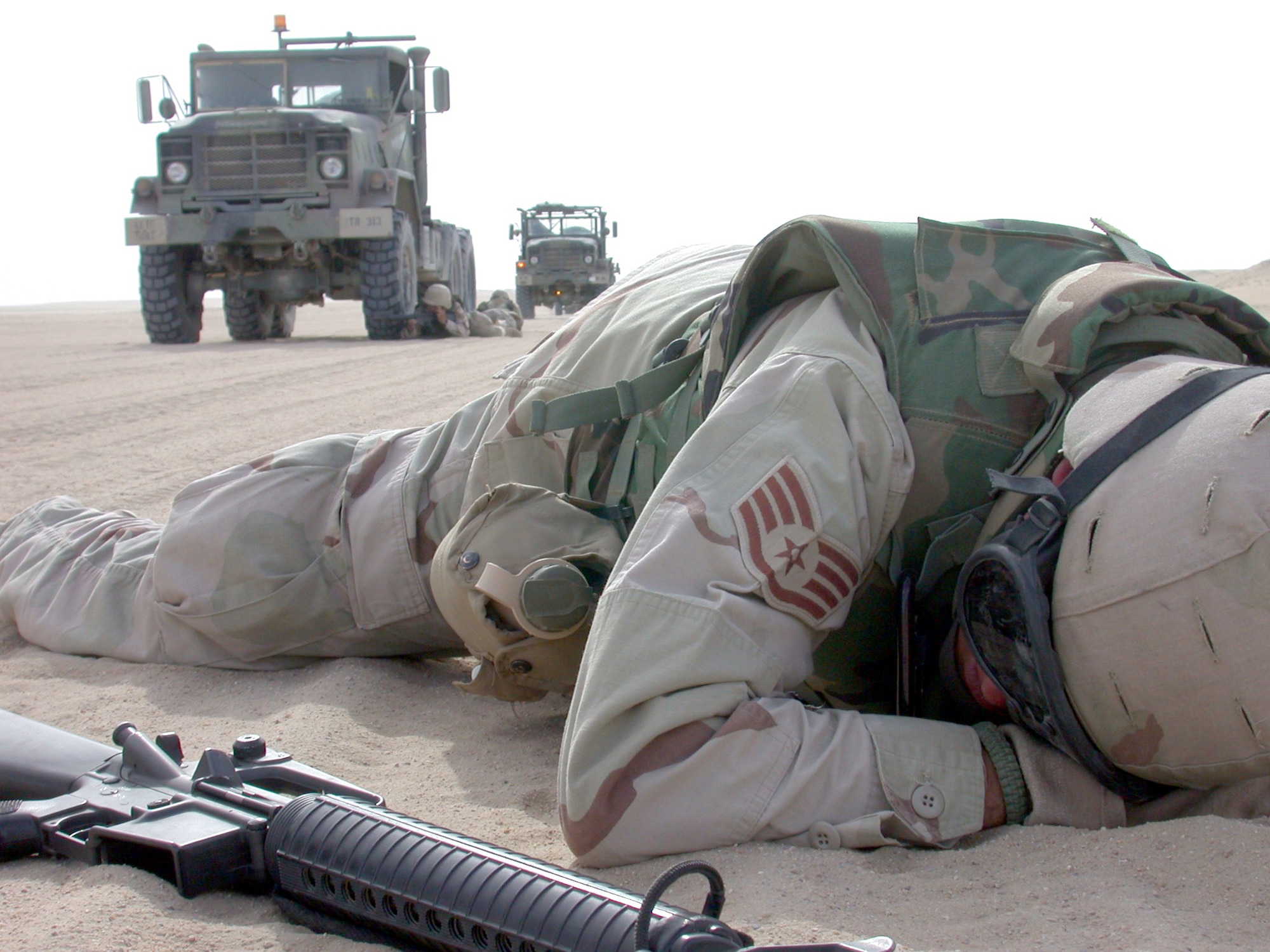 SOUTHWEST ASIA -- A transportation Airman lies "wounded" on the ground during a convoy exercise.  The exercise is designed to teach Airmen traveling in a convoy how to react if a truck is disabled and casualties are sustained.  Once a defensive ring is set up around the wounded and the disabled vehicle, the wounded are medically evacuated from a nearby landing zone.  (U.S. Air Force photo by Senior Airman James C. Dillard)
