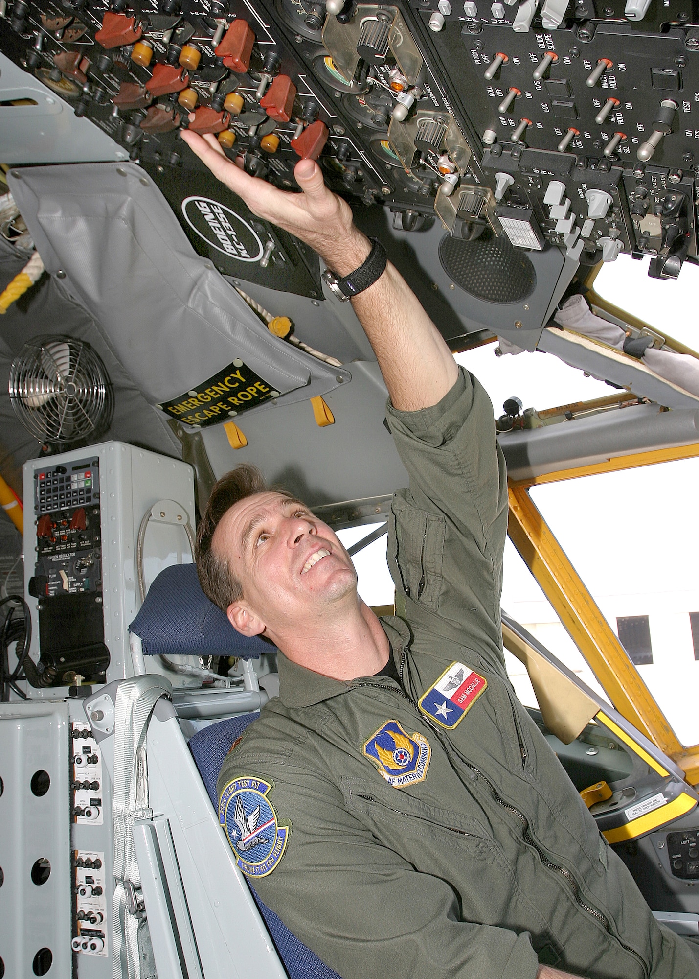LACKLAND AIR FORCE BASE, Texas -- Maj. Sam McCallie checks the switches on a control panel in the cockpit of a KC-135 Stratotanker parked on the Kelly Field ramp at the Boeing Aerospace Support Center here.   Major McCallie is chief of standardization and evaluation for the 313th Flight Test Flight.  (U.S. Air Force photo by Robbin Cresswell)
