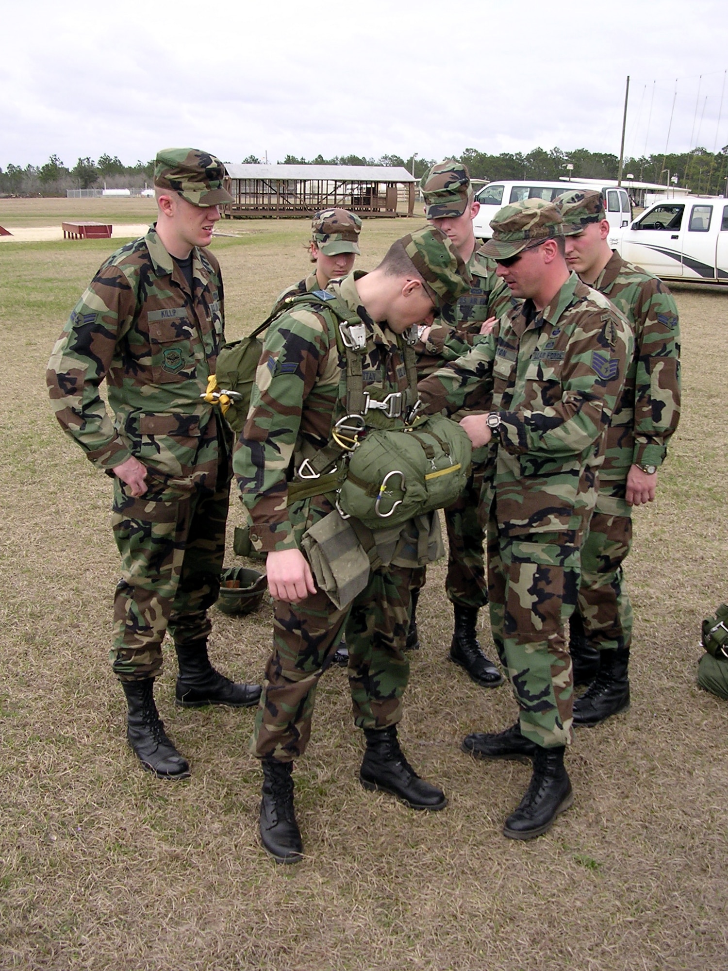 HURLBURT FIELD, Fla. -- Staff Sgt. Mike Burton assists Airman 1st Class Kevin Strattan with the static line parachute rig during a special operations and airborne weather familiarization and recruiting seminar here.  Sergeant Burton is a special operations weather forecaster assigned to the 10th Combat Weather Squadron's Detachment 2 at Fort Campbell, Ky.  Airman Strattan is assigned to the 28th Operational Weather Squadron at Shaw Air Force Base, S.C.  (U.S. Air Force photo by Senior Master Sgt. Andy Hopwood)