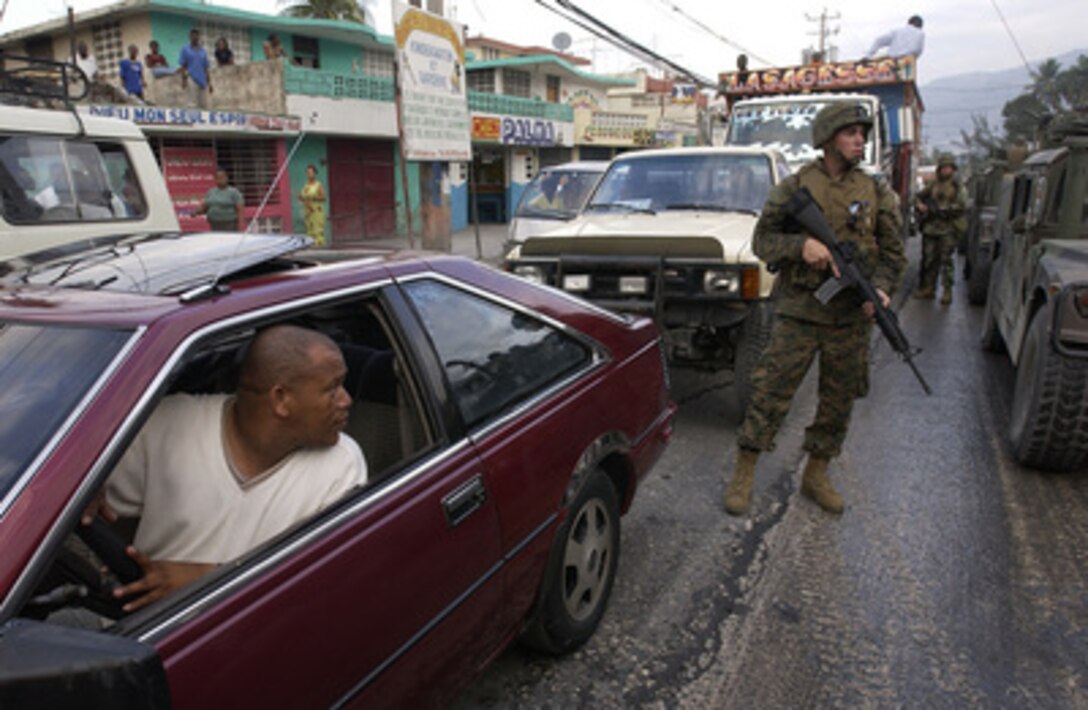 U.S. Marines from the 3rd Battalion, 8th Marine Regiment, Camp Lejeune, N.C., patrol the streets of Port-au-Prince, Haiti, on March 9, 2004. U.S. troops are deployed to Haiti at the request of the new Haitian President to help promote the constitutional political process, to prepare for the arrival of a U.N. multinational force, facilitate humanitarian assistance, and secure key sites in the capital of Port-au-Prince. 
