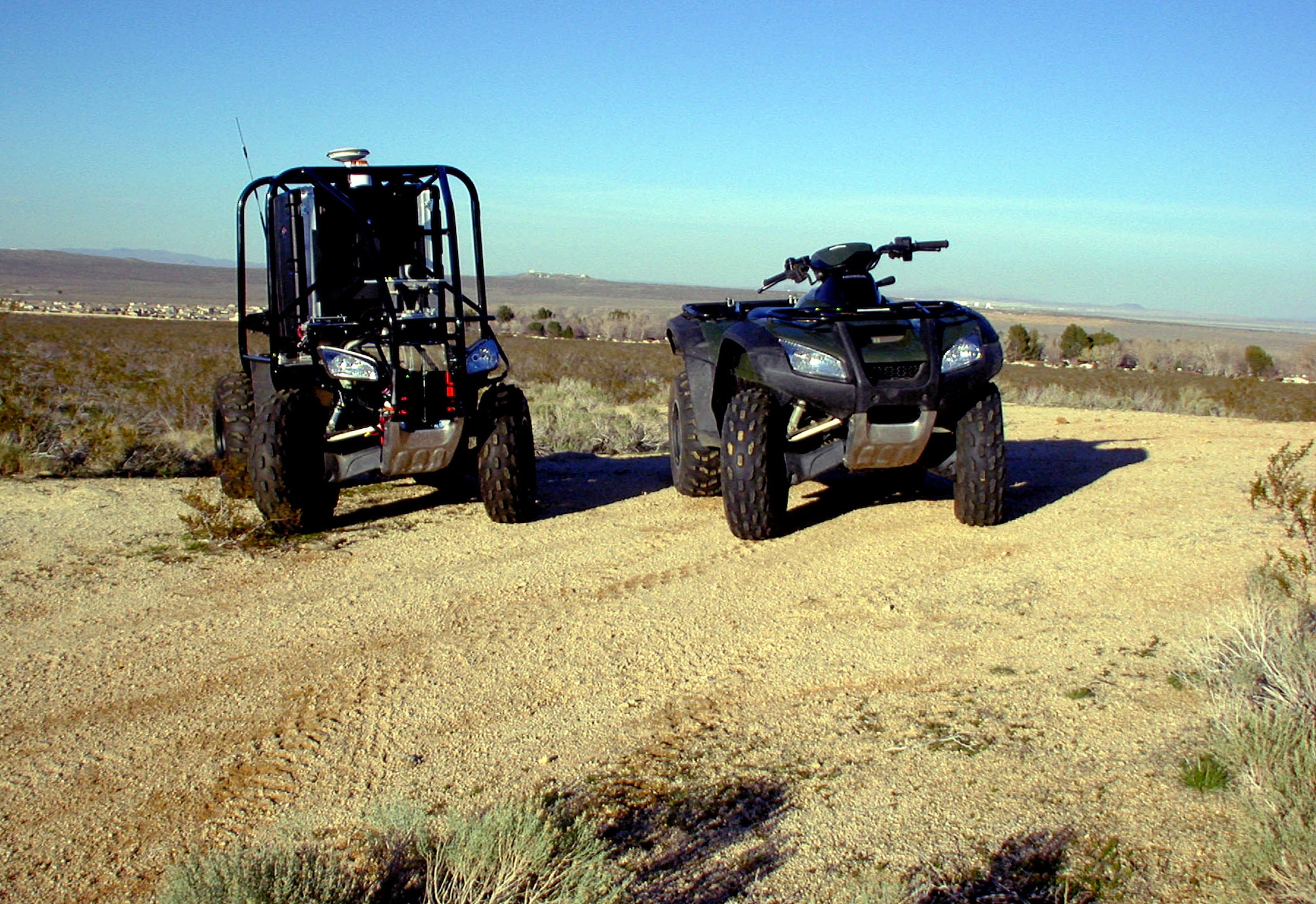 EDWARDS AIR FORCE BASE, Calif. -- The "Spirit of Las Vegas," (left) an upgraded version of an all-terrain vehicle shown on the right, is a $200,000 project expected to compete in the Defense Advanced Research Projects Agency Grand Challenge on March 13.  More than 20 unmanned ground vehicles will travel through battlefield-like conditions between Barstow, Calif., and Primm, Nev.  (U.S. Air photo by Lt. Col. Paul Daly)