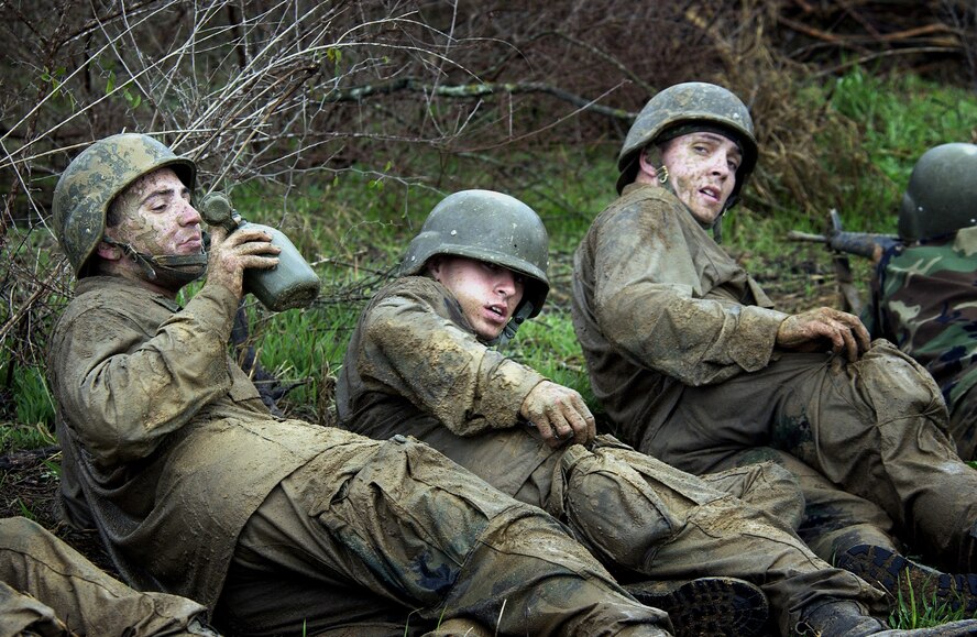 LACKLAND AIR FORCE BASE, Texas -- Basic trainees Stephen Weaver (left), Christopher Mann (middle) and Ryan Locke rest after completing "Hell's Half Mile" at Warrior Week's training ground.  "Hell's Half Mile" is a grueling obstacle ladden combat tactics course designed to expose Air Force basic trainees to a combat like environment. The training during Warrior Week prepares trainees for the possibility of world wide deployment almost immediately upon arrival at their first duty station.  The trainees are in their fifth week of training and are one week away from graduation.  (U.S. Air Force photo by Master Sgt. Efrain Gonzalez)