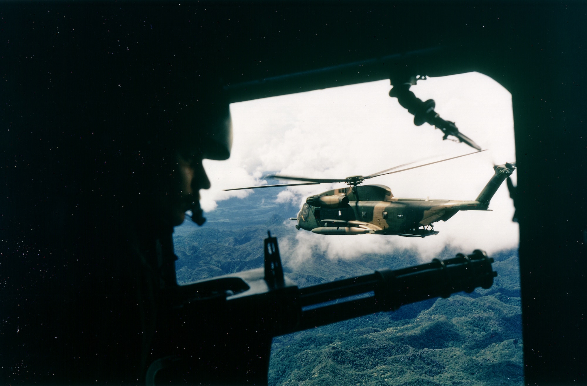 An HH-53 Huskie, a specialized helicopter designed for search and rescue, of the 40th Aerospace Rescue and Recovery Squadron as seen from the gunner's position, in Vietnam, October 1972. (U.S. Air Force photo by Ken Hackman)