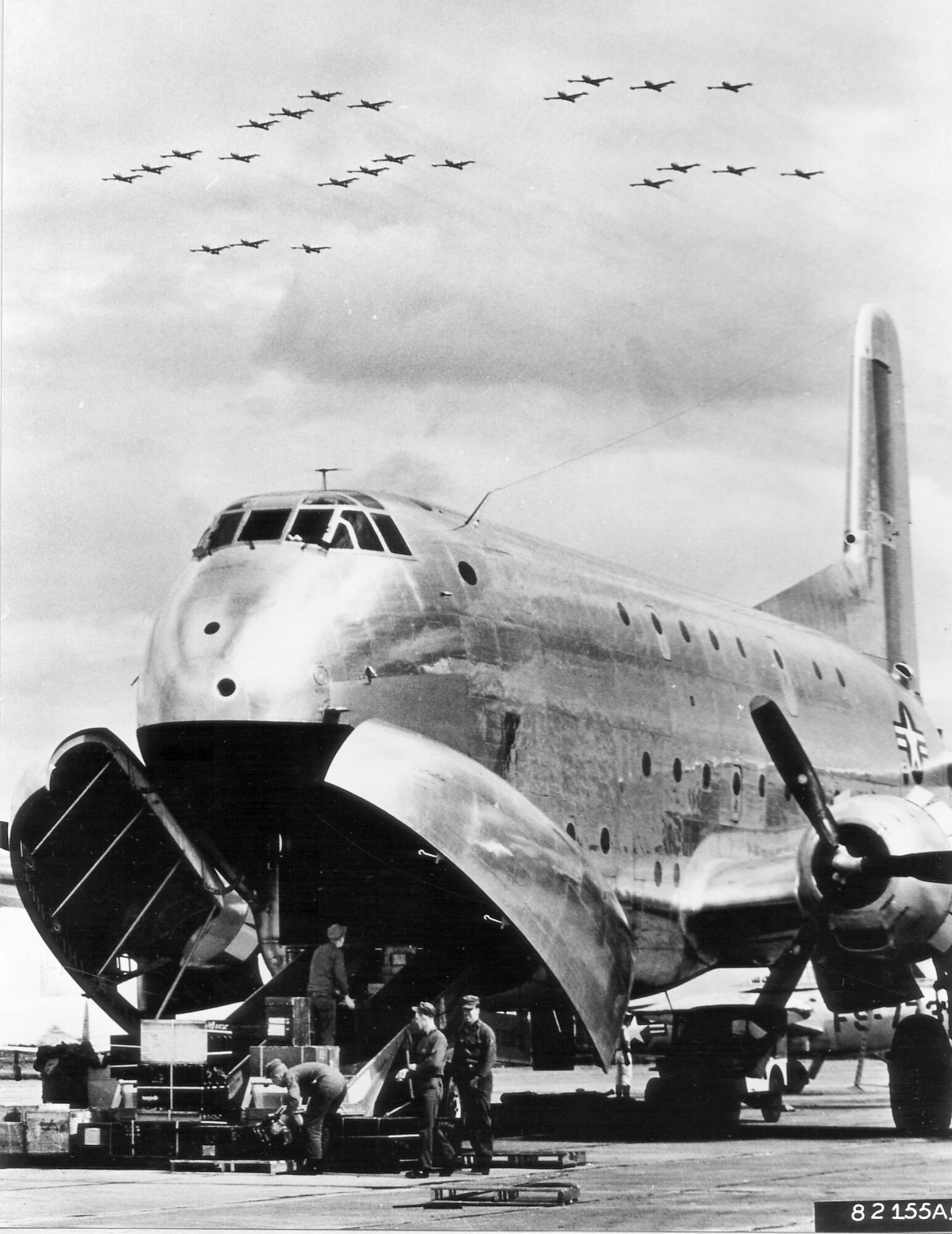 1950s -- Flashing through the sky above a U.S. Air Force C-124 Globemaster, F-84G Thunderjets of the 27th Fighter Escort Wing arrive at a Japan Air Defense Force base in northern Japan after completing a trans-Pacific flight.  The F-84s flew 7,800 miles from their home base to Japan and set a new record for over-water flight by single engine fighter aircraft.  They flew the last 2,575 miles of their trip using in-flight refueling, October 1952. (U.S. Air Force photo)