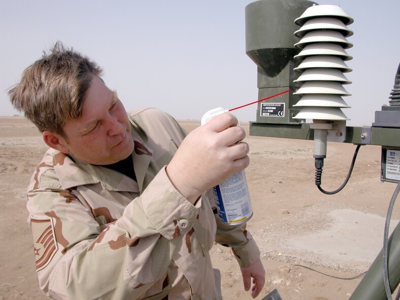 TALLIL AIR BASE, Iraq (AFPN) -- Master Sgt. Richard Blume sprays compressed air on an automated weather station to remove dust from the equipment.  Sergeant Blume is the base's weather flight superintendent and is deployed here from Moody Air Force Base, Ga. (U.S. Air Force photo by Tech. Sgt. Bob Oldham)