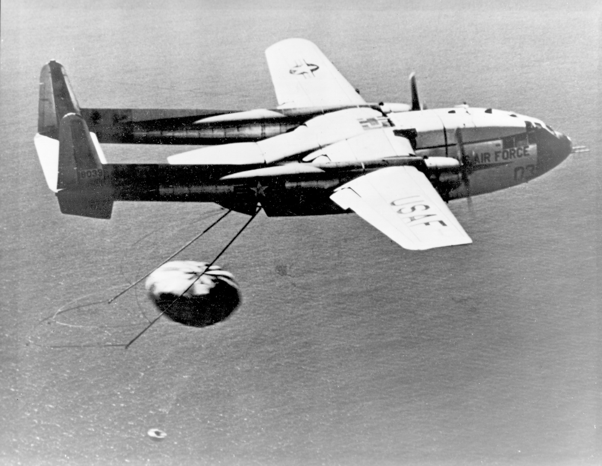 On Aug. 19, 1960, a C-119J Flying Boxcar made the world's first midair recovery of a capsule returning from orbit when it "snagged" the parachute lowering the Discoverer XIV satellite at 8,000 feet altitude, 360 miles southwest of Honolulu, Hawaii.  The aircraft  recovered a Corona capsule returning from Space, and was specially modified for the mid-air retrieval.  (U.S. Air Force photo)