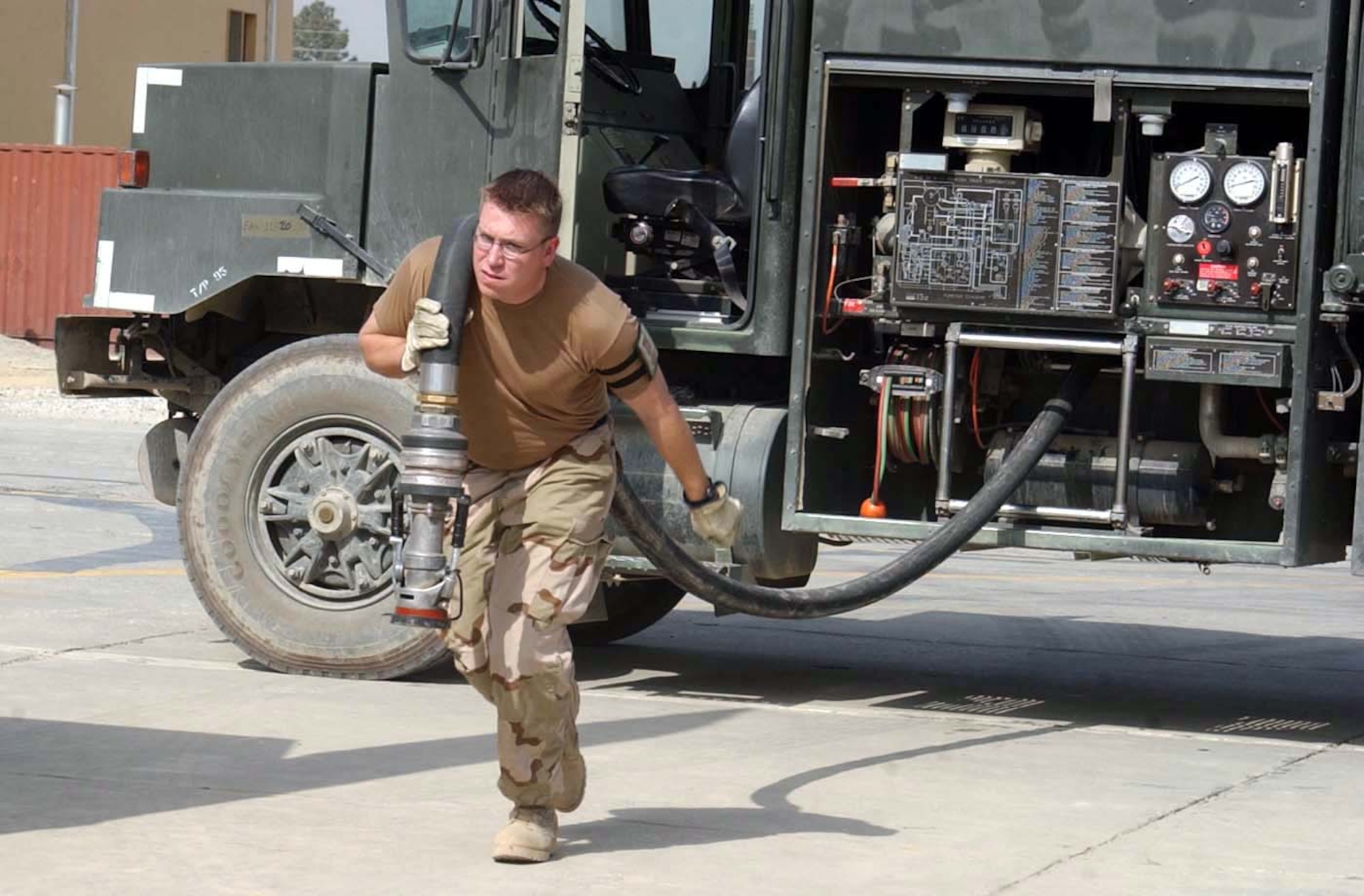 BAGRAM AIR BASE, Afghanistan -- Staff Sgt. Shannon Walline uncoils a fuel hose as he sets up for an A-10 Thunderbolt II refueling operation.  Sergeant Walline is deployed from Davis-Monthan Air Force Base, Ariz.  (U.S. Air Force photo by Master Sgt. Jeff Szczechowski)