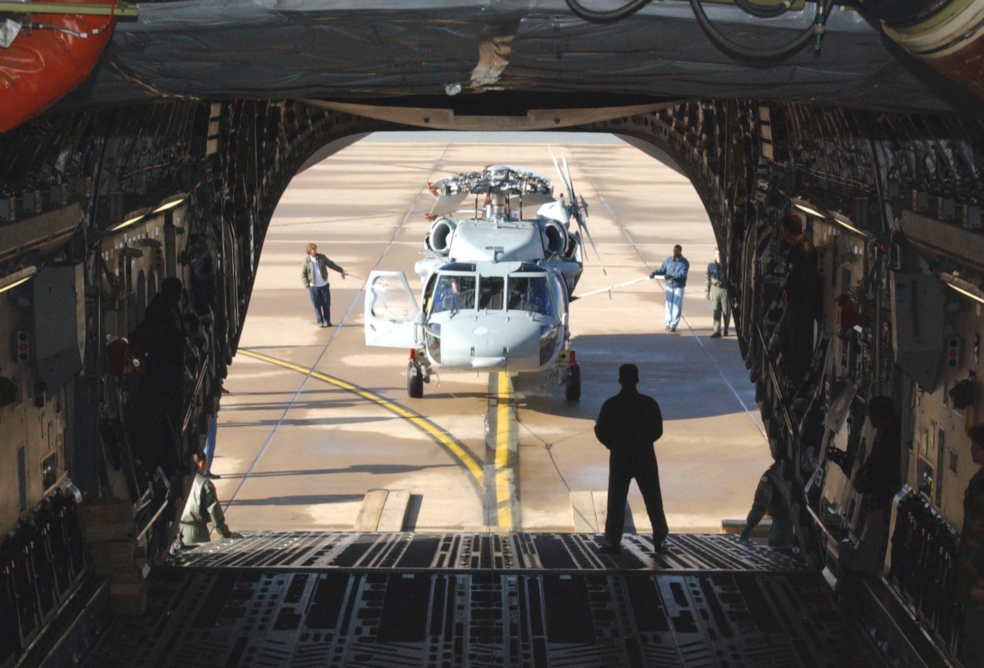 ALTUS AIR FORCE BASE, Okla. -- Navy and Air Force specialists prepare to load an MH-60S Knight Hawk helicopter into a C-17 Globemaster III during a load validation here.  It was the first time a Knight Hawk had been loaded into a C-17.  The test was successful.  (U.S. Air Force photo by Airman 1st Class Ricky Rose)