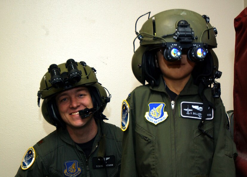 EIELSON AIR FORCE BASE, Alaska -- Kameron Ballard-Huffman, the Fighter Pilot for a Day here March 18, tries on a set of night-vision goggles under the watchful eye of  Maj. Steve Latham.  The program lets terminally ill children see what it is like to be a fighter pilot.  Kameron is in the end stage of a rare liver disease.  He is from Husila, Alaska, a town about 250 miles northwest of Fairbanks.  Major Latham is assigned to the Alaska Air National Guard's 210th Rescue Squadron.  (U.S. Air Force photo by Senior Airman Joshua Strang)
