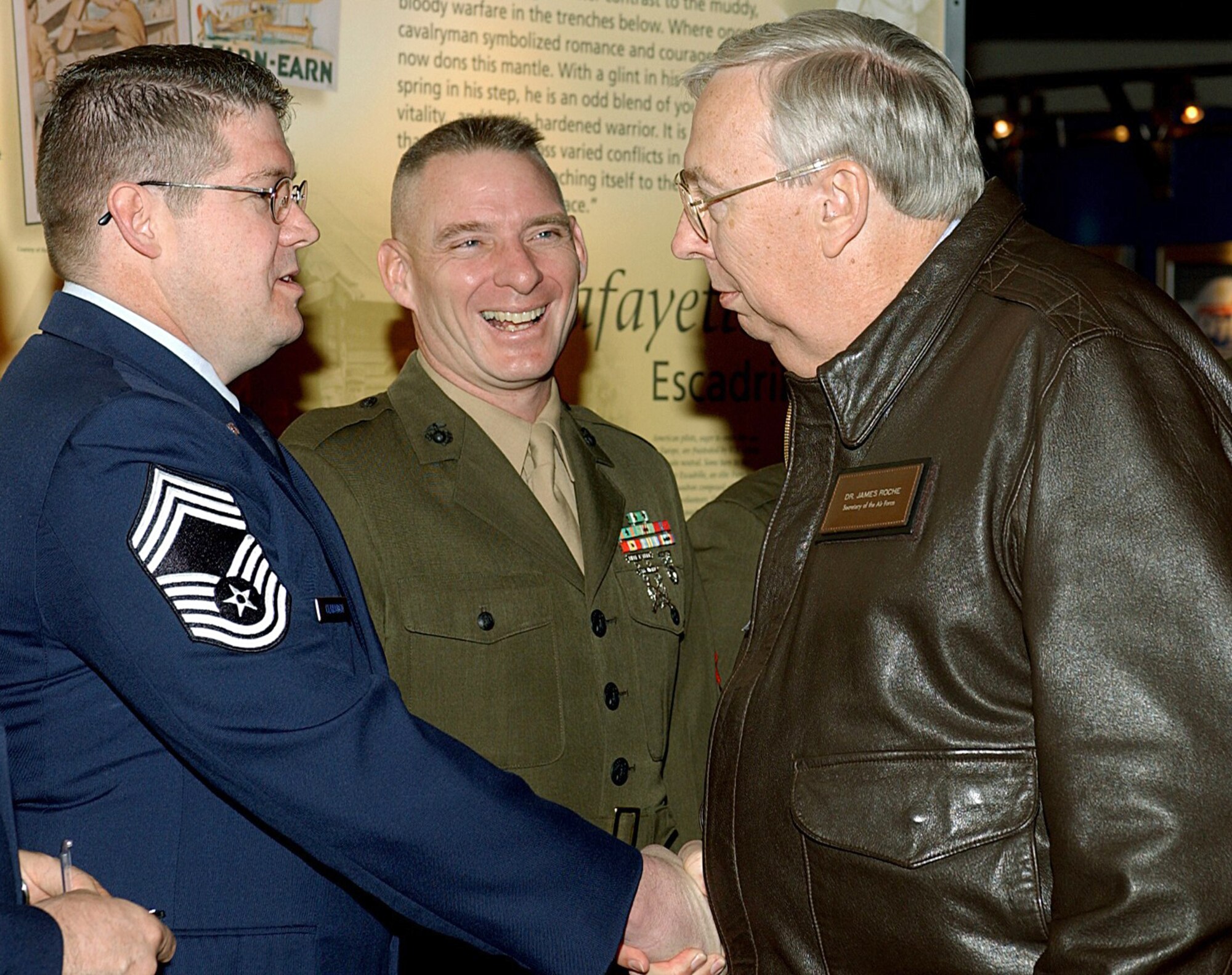 DAYTON, Ohio -- Secretary of the Air Force Dr. James G. Roche speaks with Chief Master Sgt. Donald Clabaugh (left) and Marine Corps Gunnery Sgt. Brian Hamilton before the Air Force Institute of Technology graduation ceremony March 23 at the Air Force Museum here.  The two noncommissioned officers were among the first enlisted students to obtain AFIT degrees.  Eight Air Force and six Marine Corps senior NCOs graduated as part of the Class of 2004.  (U.S. Air Force photo by Larry Davenport)