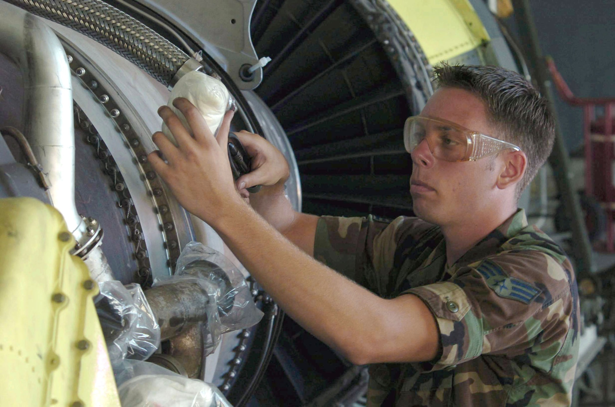 ANDERSEN AIR FORCE BASE, Guam -- Senior Airman Lester Smith uses a safety wire to secure a quick-disconnect line to prevent leaks on a B-52 Stratofortress engine.  Airman Smith is an engine mechanic from the 5th Bomb Wing at Minot Air Force Base, N.D.  The wing is the first rotation to deploy to Guam following the decision to station a bomber force here.  (U.S. Air Force photo by Master Sgt. Val Gempis)