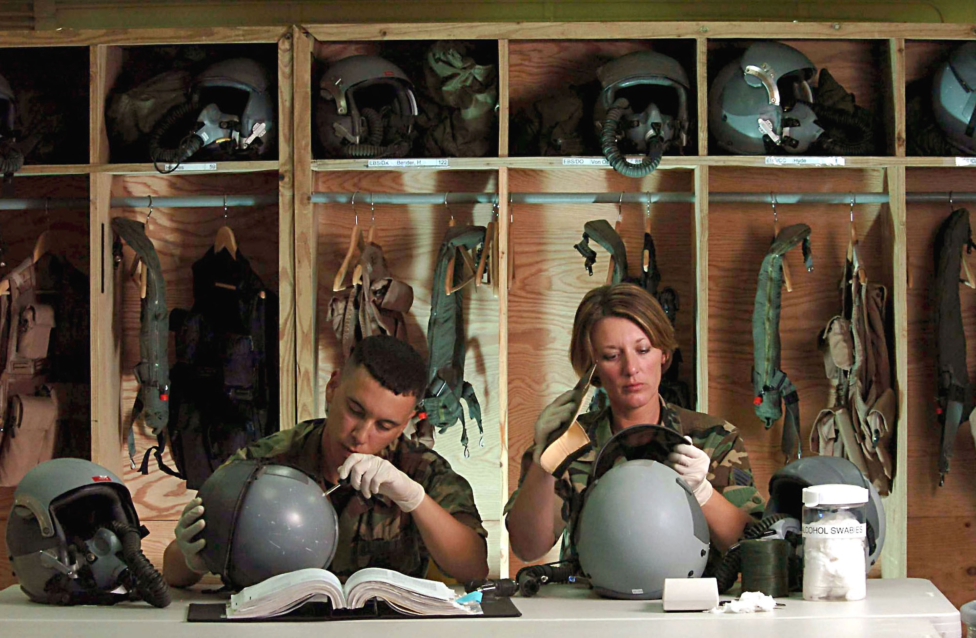 ANDERSEN AIR FORCE BASE, Guam -- Staff Sgt. Terilyn Morrison (right) and Airman Felipe Maymi-Baez inspect helmets belonging to B-52 Stratofortress aircrews here.  Sergeant Morrison and Airman Maymi-Baez are both life-support technicians from the 5th Bomb Wing at Minot Air Force Base, N.D.  The wing is the first rotation to deploy to Guam following the decision to station a bomber force here.  (U.S. Air Force photo by Master Sgt. Val Gempis)
