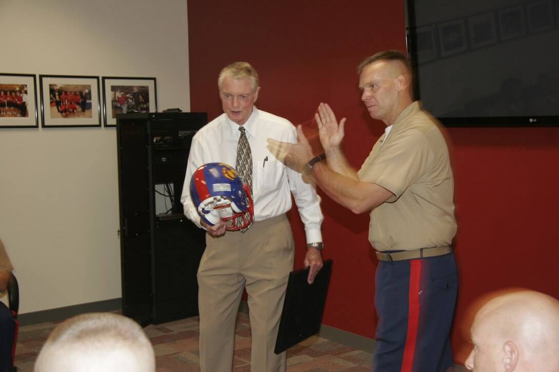 Dr. Tom Osborne receives a Marine Corps football helmet from Maj. Sean T. Quinlan on behalf of the Recruiting Station Des Moines Marines Sept. 23 at the University of Nebraska athletics department conference room. Osborne took time out of his busy schedule to speak to the Marines about leadership. Osborne, the long-time coach for the university's historical football program now serves as the university's athletics director.