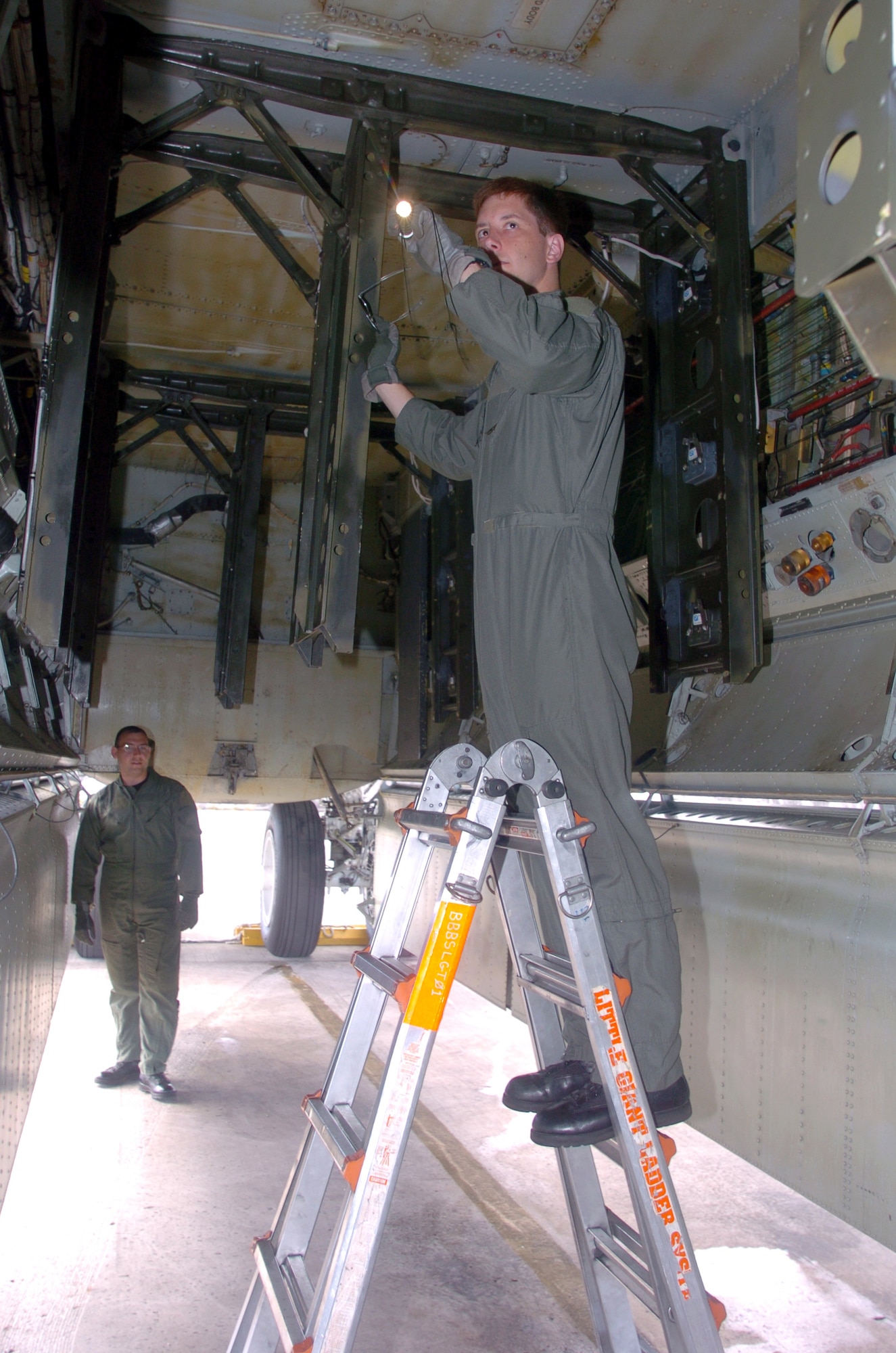 ANDERSEN AIR FORCE BASE, Guam -- Capt. Robby Castle (foreground), a radar navigator, and 2nd Lt. Jeremy Fairaizl, an electronic warfare officer, inspect inside the bomb bay of their aircraft before a mission here.  Six B-52s and about 300 support people from Minot Air Force Base, N.D., are the first to deploy here following the decision to station a rotating bomber force here.  Both Airmen are from the 23rd Bomb Squadron at Minot AFB.  (U.S. Air Force photo by Master Sgt. Val Gempis)