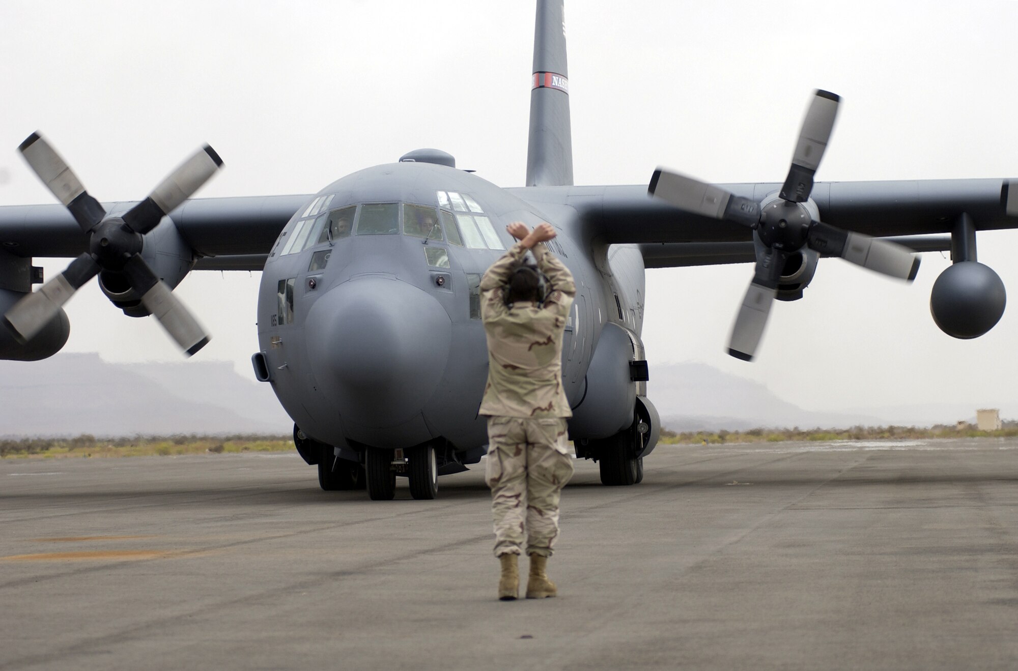 ATAR AIRPORT, Mauritania -- Tech. Sgt. Eric Wilhelm marshals a C-130 Hercules into its parking area.  Sergeant Wilhelm is an aerial porter for the 86th Contingency Response Group.  He is the deployed mission-support team's chief.  The team pulled Soldiers from Africa who were working on the Pan Sahel Initiative.  The Soldiers trained the African military in force protection, border patrol and anti-terrorism tactics.  (U.S. Air Force photo by Tech. Sgt. Rich Puckett)