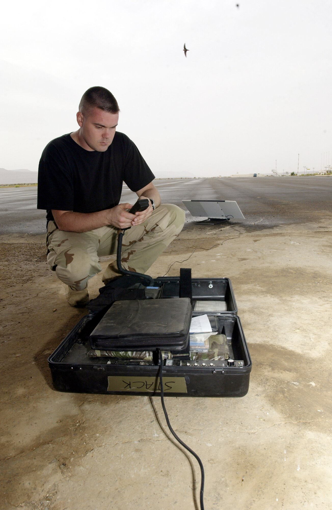 ATAR AIRPORT, Mauritania -- Staff Sgt. Sean Stackhouse sets up an international maritime satellite terminal for his deployed mission-support team.  The team pulled Soldiers from Africa who were working on the Pan Sahel Initiative.  The Soldiers trained the African military in force protection, border patrol and anti-terrorism tactics.  Sergeant Stackhouse is a communications specialist from the 86th Contingency Response Group.  (U.S. Air Force photo by Tech. Sgt. Rich Puckett)