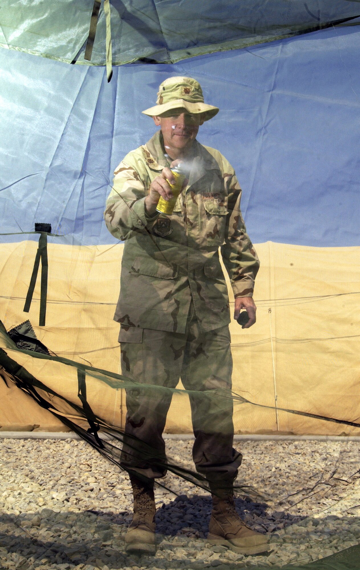 TALLIL AIR BASE, Iraq -- Major Don Savage spot treats a mosquito net with Permethrin Arthropod Repellent here March 30. Maj. Savage is a public health officer with the  407th Expeditionary Medical Group. Public health people treat mosquito nets in order to prevent Leishmaniasis, an infectious desease spread by sand fleas and sand flies in this area. (U.S. Air Force photo by Staff Sgt. Christina Rumsey)