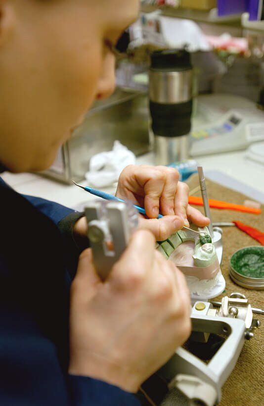 ROYAL AIR FORCE LAKENHEATH, England -- Staff Sgt Jodi Hildebrandt uses melted wax to make a mold for a gold crown here March 24. SSgt. Hildebrandt is a dental lab craftsman  with the 48th Dental Squadron here. (U.S. Air Force photo by Airman Chris Walkenhorst)