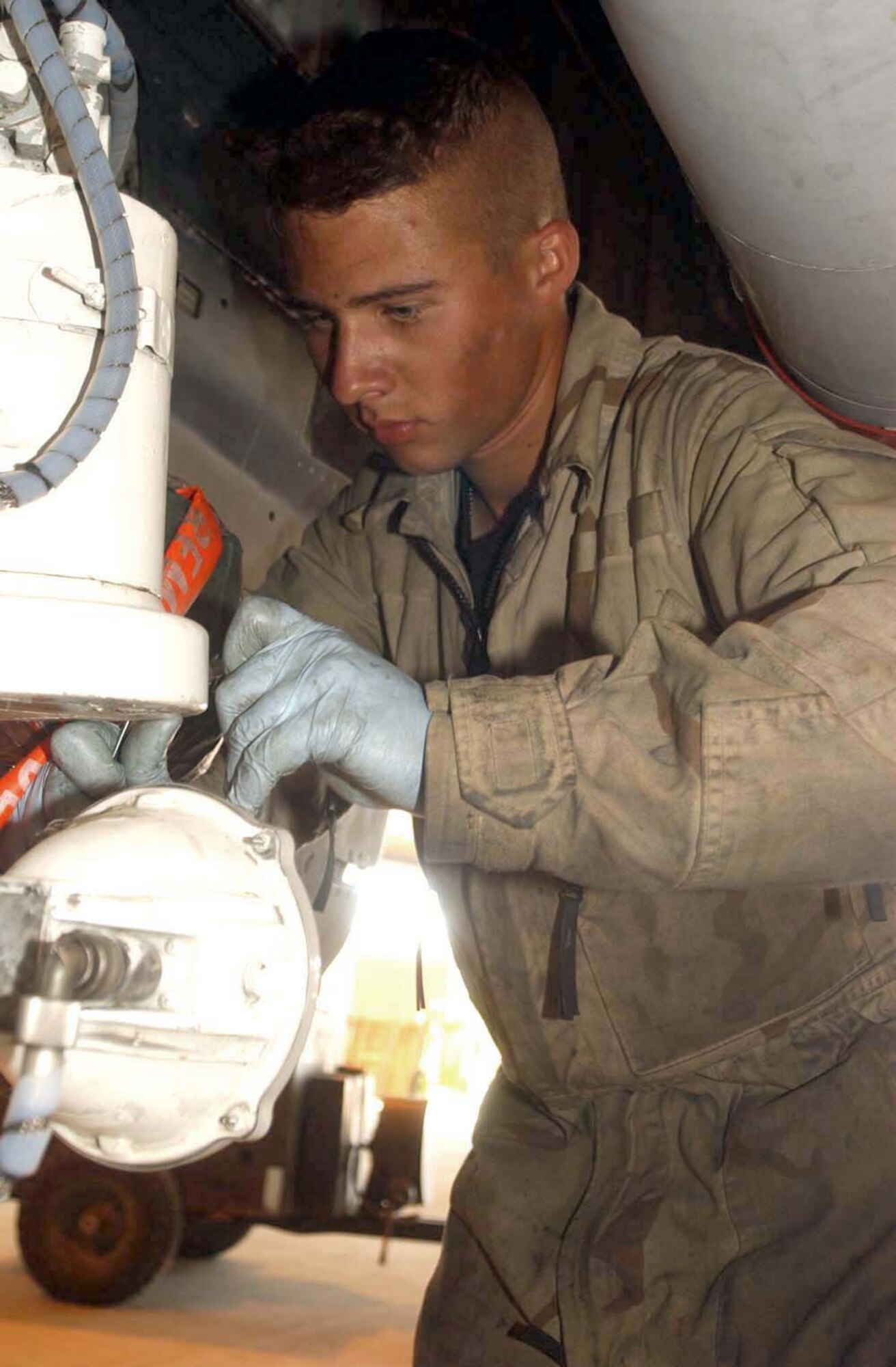 BAGRAM AIR BASE Afghanistan -- Senior Airman Shane Neel installs a nose wheel steering cover on an A-10 Thunderbolt II.  He is an aircraft maintenance journeyman with the 455th Expeditionary Aircraft Maintenance Squadron.  (U.S. Air Force photo by Master Sgt. Jeff Szczechowski)