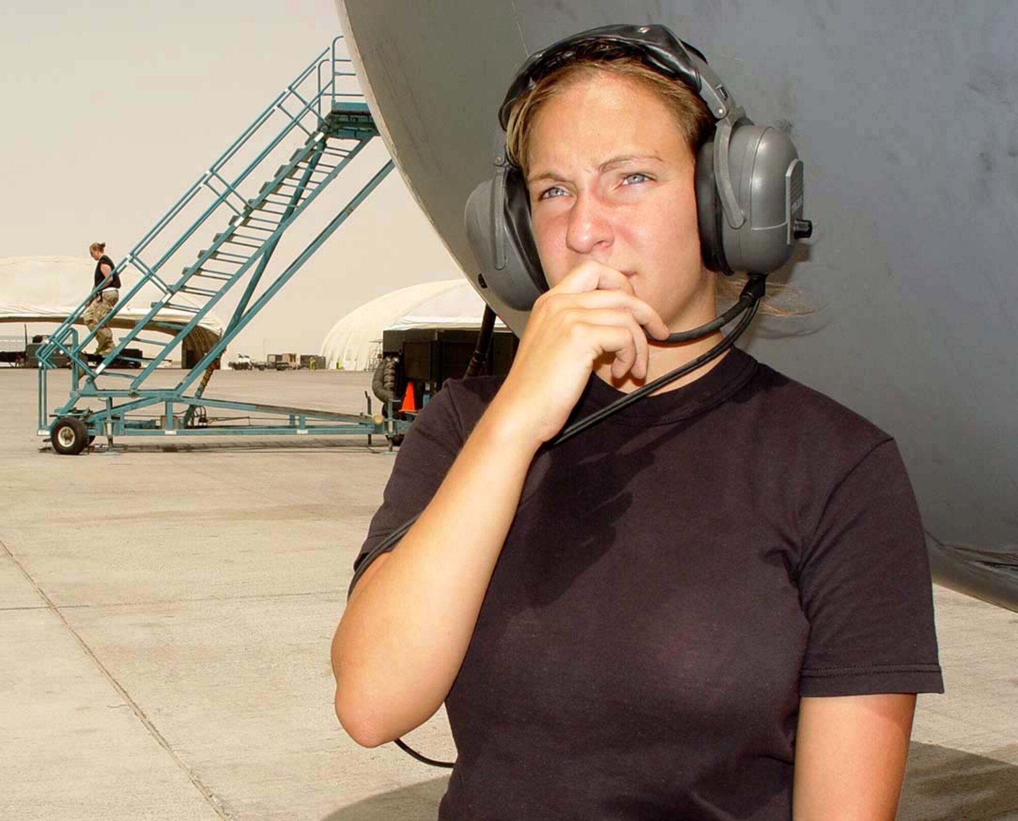 SOUTHWEST ASIA -- Airman 1st Class Lacey Fontenot talks on her headset with other aircraft maintainers while preparing to launch a KC-10 Extender.  She is an aerospace propulsion journeyman with the 380th Expeditionary Aircraft Maintenance Squadron at a forward-deployed location.  (U.S. Air Force photo by Capt. Angela Smith)
