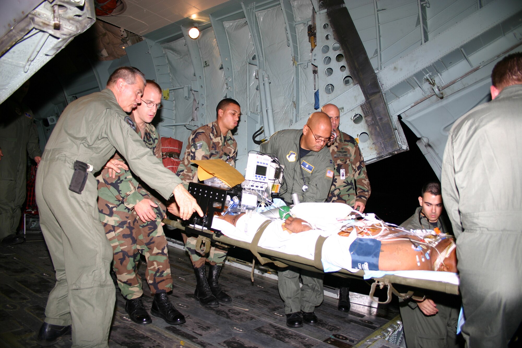 SAN ANTONIO -- Capt. Edwin Maldonado (center) helps move a critically ill Soldier from a C-141 Starlifter into an ambulance at San Antonio International Airport on April 29.  Captain Maldonado was part of the critical care air transport team of medics from Wilford Hall and Brooke Army medical centers that ensured 14 servicemembers injured in Iraq were moved safely to BAMC.  Captain Maldonado is a critical-care nurse with Wilford Hall's 759th Surgical Operations Squadron at Lackland Air Force Base, Texas.  (U.S. Air Force photo by Sue Campbell)