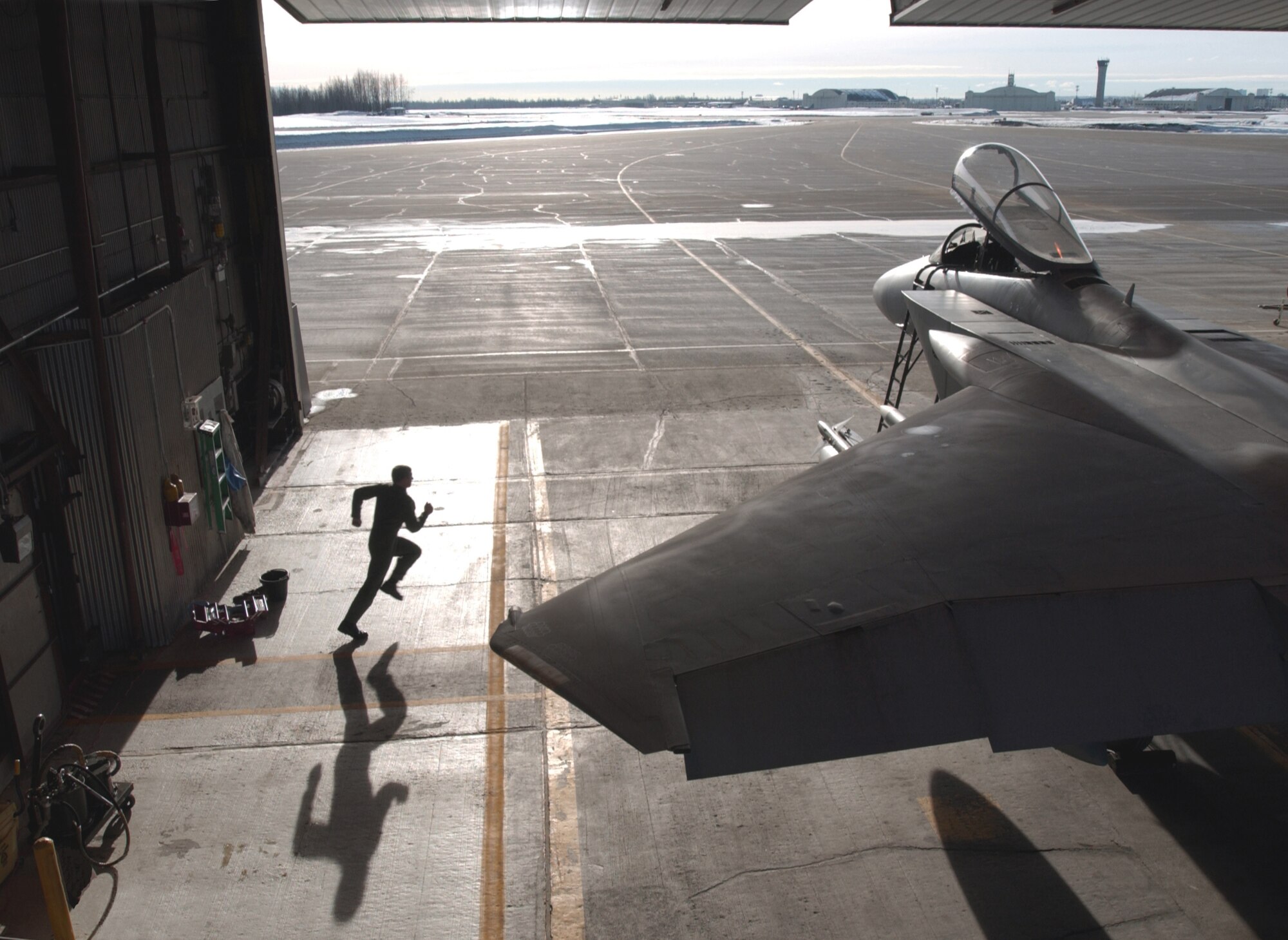 ELMENDORF AIR FORCE BASE, Alaska -- Maj. Tom O'Berg sprints to an F-15 Eagle standing alert here.  The 12th Fighter Squadron stands alert as part of Operation Noble Eagle, the defense of North American airspace.  Within minutes of receiving a call reporting unidentified aircraft approaching U.S. airspace, he and other pilots will taxi their aircraft out of the combat alert cell and fly over Alaska's Chugach mountain range.  (U.S. Air Force photo by Master Sgt. Scott Wagers)