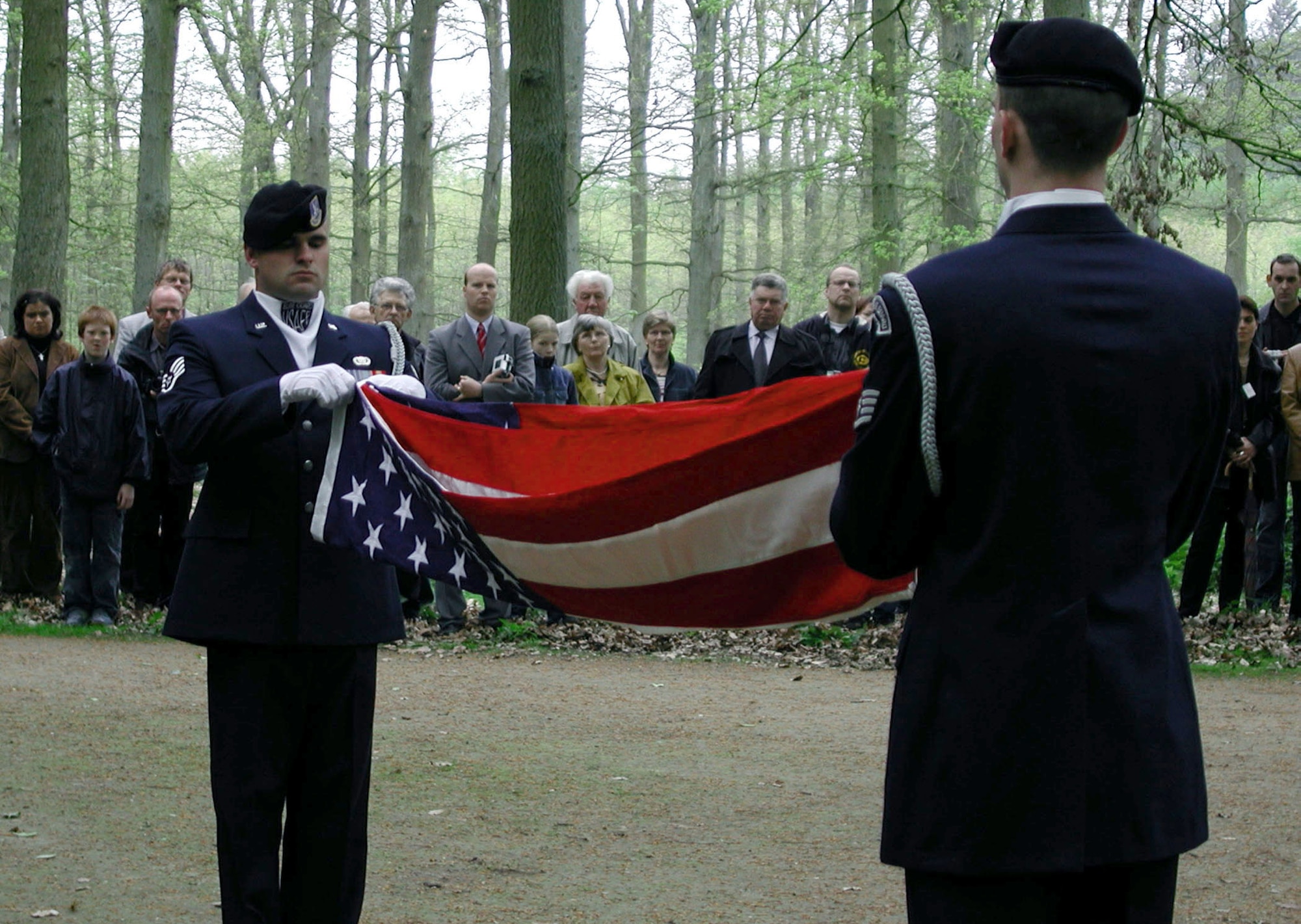 DINKLAGE, Germany -- Staff Sgts. Kyle Luker and Christopher Murphy fold an American flag during a memorial dedication ceremony here April 29.  The flag was presented to Army veteran Robert Franke.  His brother, along with his aircrew, was killed when their B-24 Liberator bomber was shot down by German fighter aircraft and crashed here during World War II.  The Airmen are assigned to the 568th Security Forces Squadron's elite guard flight honor guard at Ramstein Air Base, Germany.  (U.S. Air Force photo by Capt. Chris Watt)