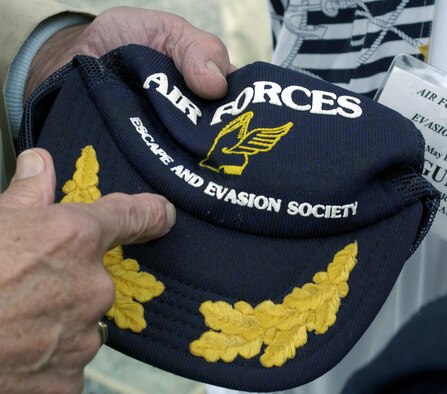 WASHINGTON -- An Air Forces Escape and Evasion Society member explains the significance of the winged boot emblem on his hat during a visit to the newly opened World War II Memorial here May 3.  He said the winged boot signified that he had walked to freedom while evading enemy capture after he was shot down in World War II.  The society comprises both U.S. Airmen who successfully evaded capture after bailing out of their aircraft over Europe in World War II and a number of the European civilians who helped them.  (U.S. Air Force by Master Sgt. Jim Varhegyi) 