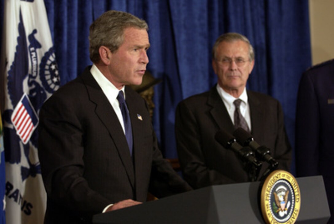 President George W. Bush makes a statement to the press in the Pentagon on May 10, 2004, as Secretary of Defense Donald H. Rumsfeld looks on. 