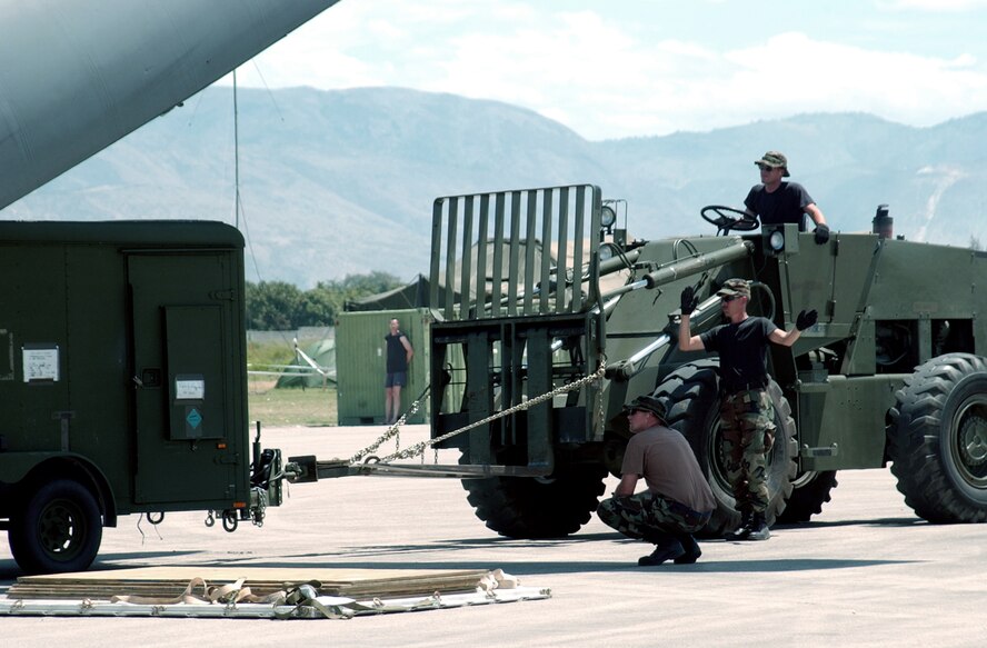 PORT-AU-PRINCE, Haiti -- Master Sgt. Mike Powell guides forklift driver Staff Sgt. Jacob Tittle while Staff Sgt. Alex Henson serves as spotter.  The Airmen are assigned to the 84th Aerial Port Squadron here supporting Operation Secure Tomorrow.  (U.S Air Force photo by 1st Lt. Rob Goza)